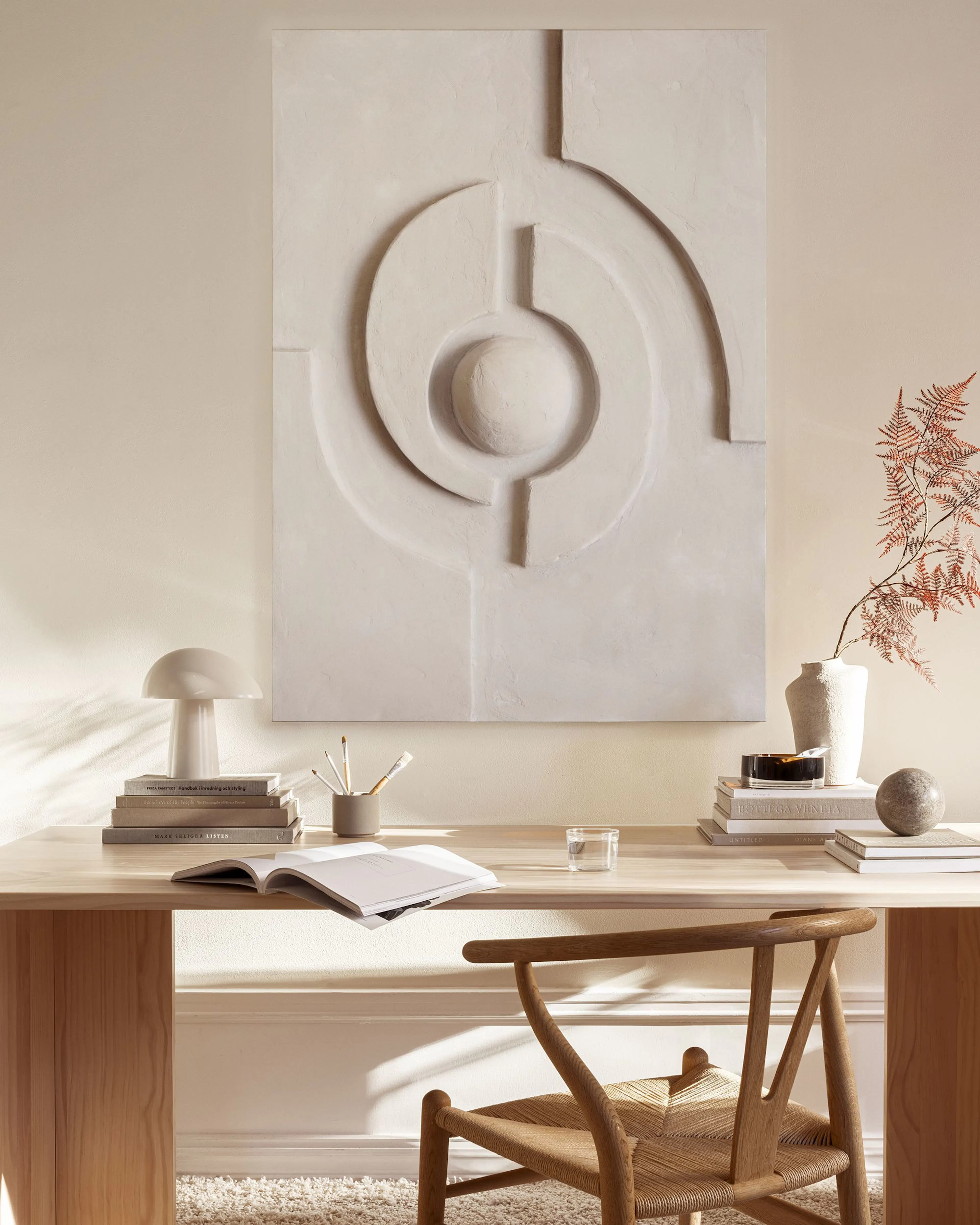 Een canvas met een beige abstract patroon van organische vormen en lijnen, hangend in een neutrale woonkamer.