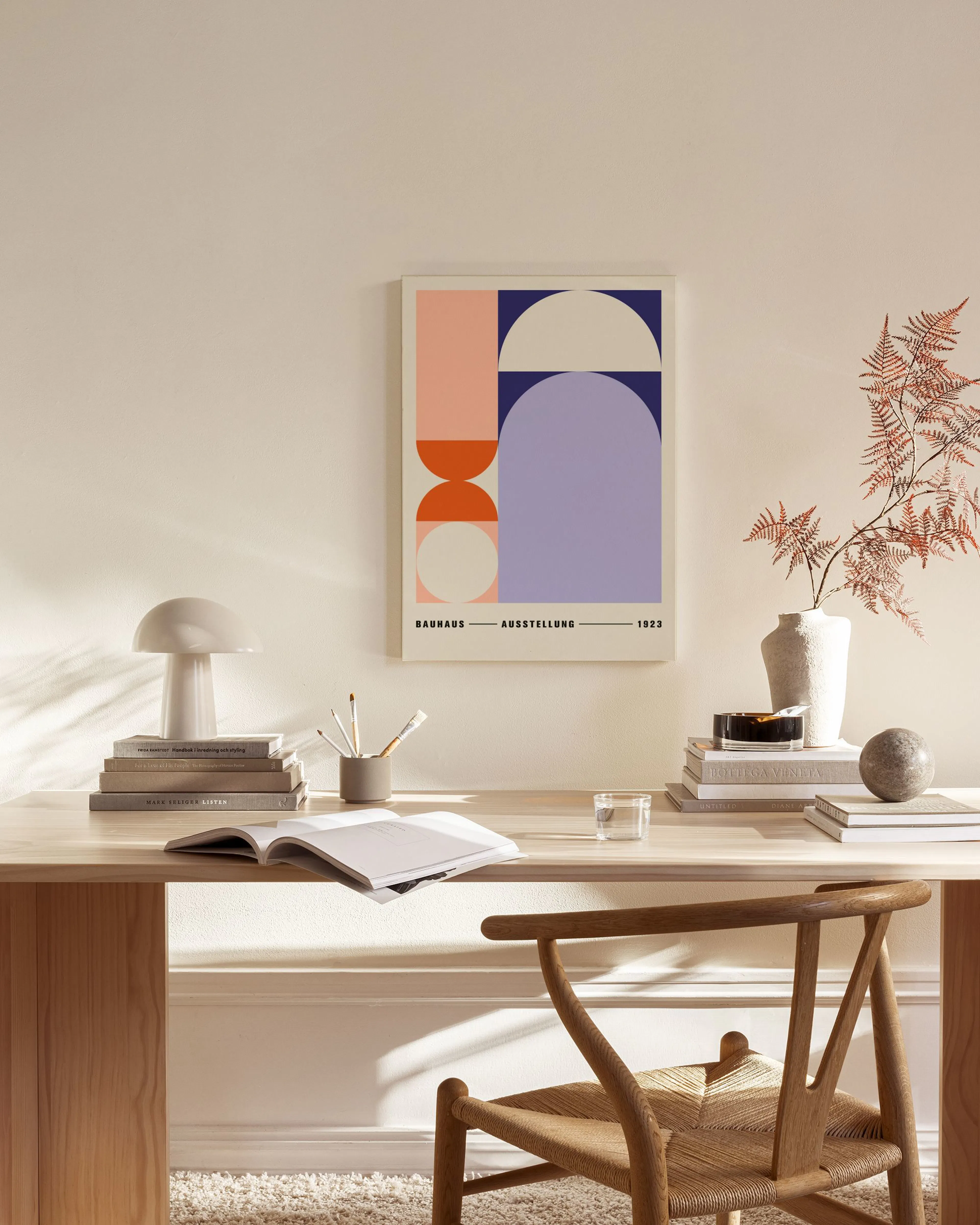 Leinwandbild mit geometrischen Formen in Pastellfarben, darunter Rosa, Orange und Lila, hängend in einem modernen Wohnzimmer.