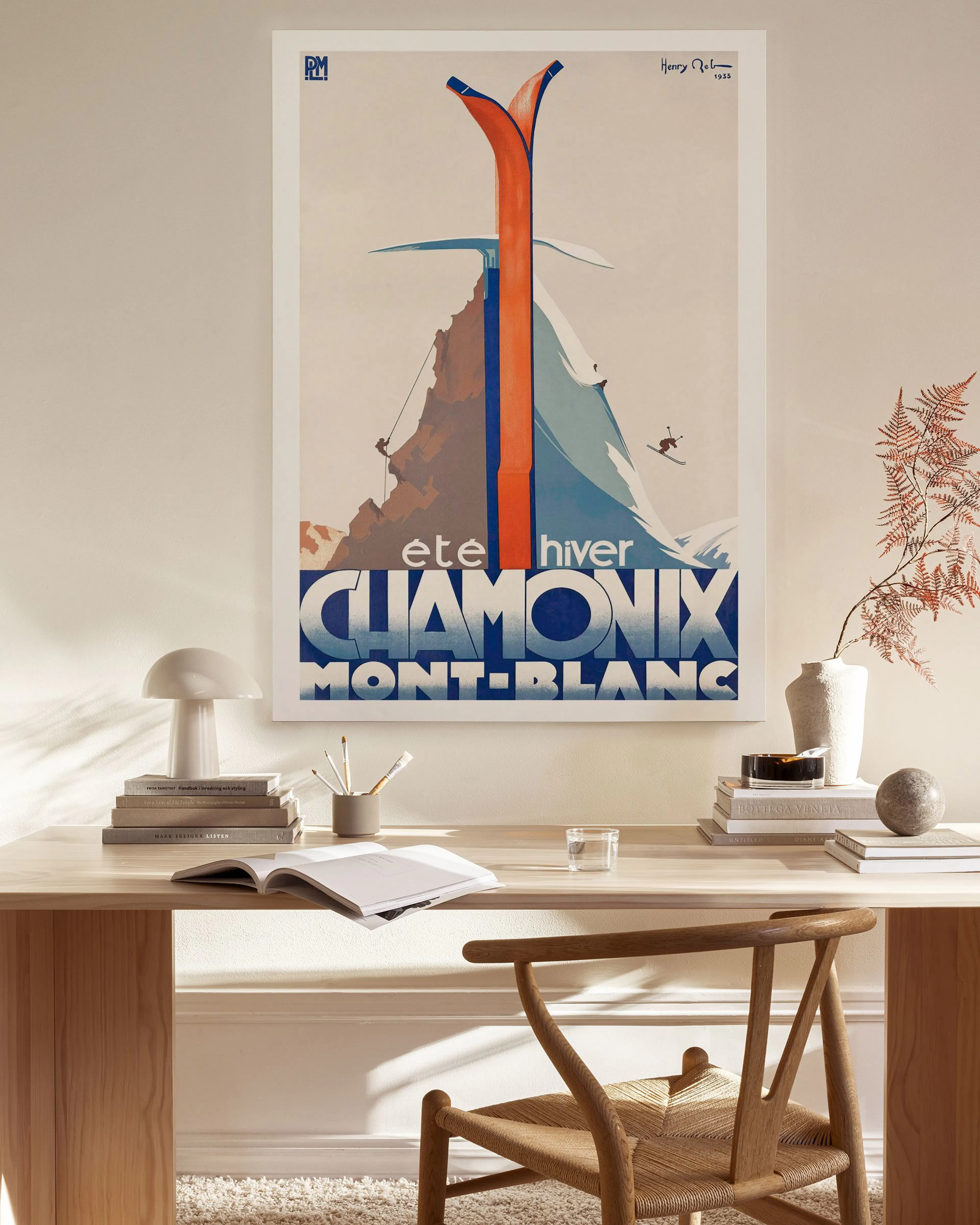Vintage Chamonix ski poster with orange skis, a mountain climber, and a skier on a snowy mountain.