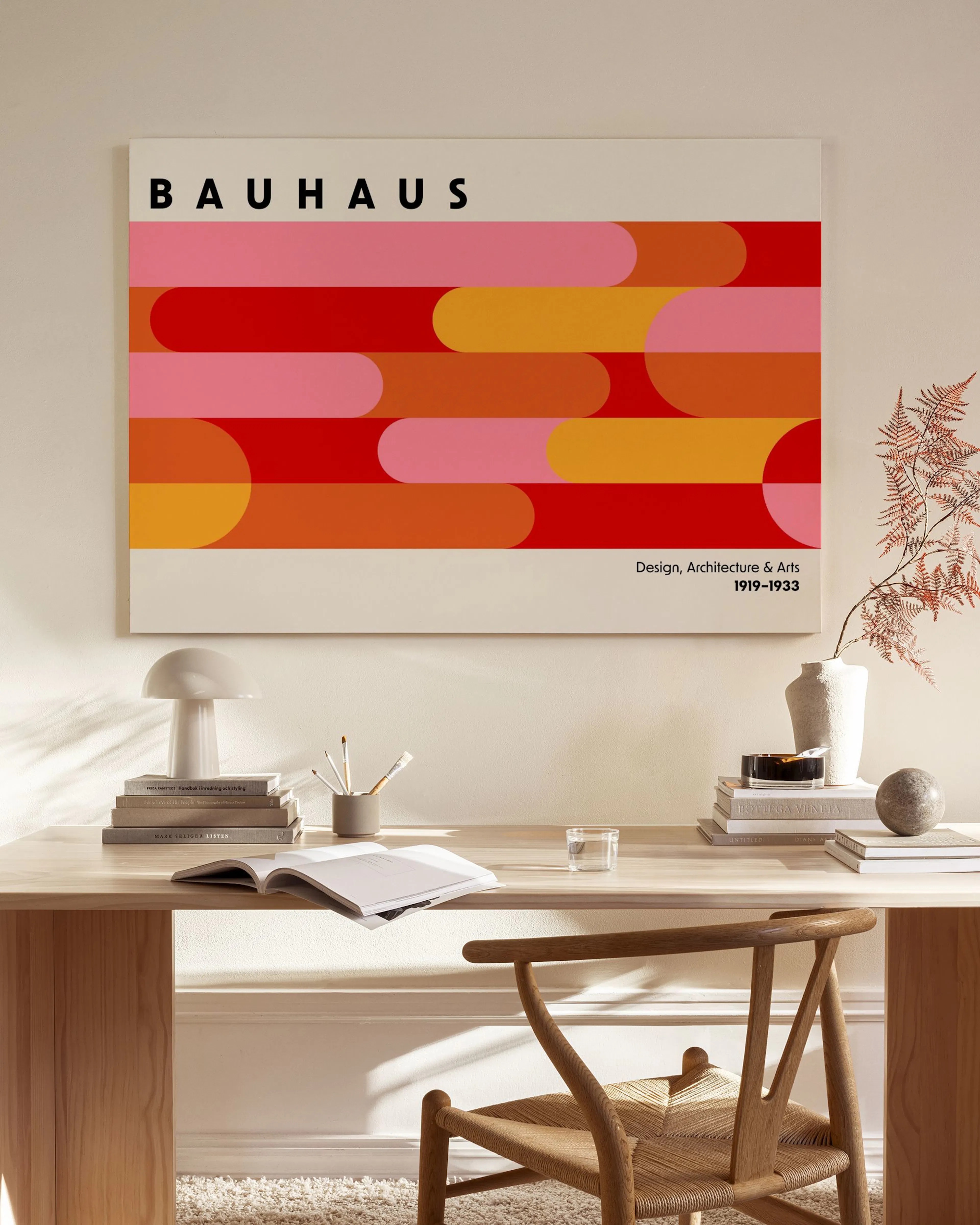 Lienzo Bauhaus con patrón de formas geométricas en tonos rojos, rosas y naranjas. Incluye el texto Bauhaus y Design, Architectur