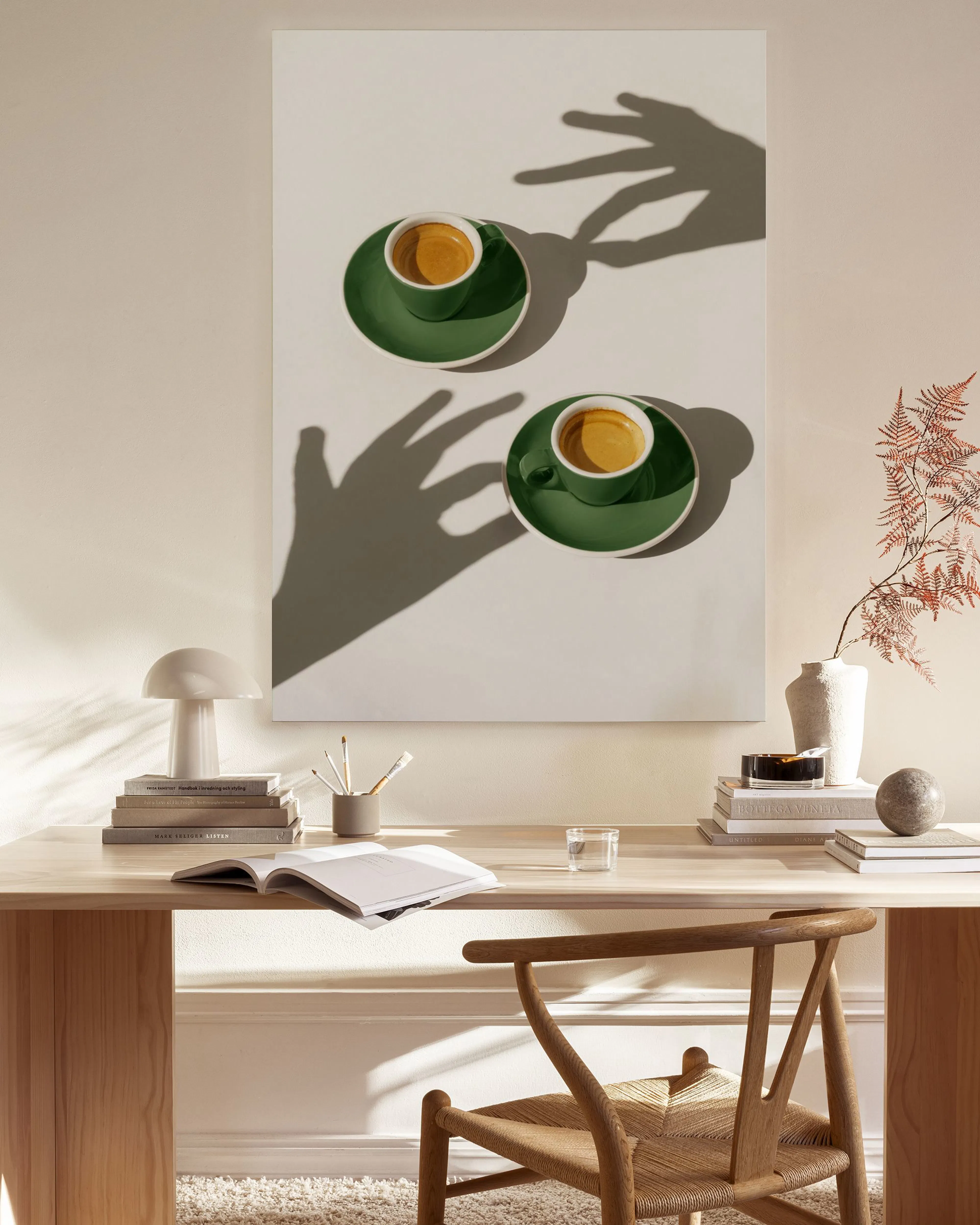 Leinwandbild mit zwei grünen Espressotassen und Untertassen auf weißem Grund, mit Schatten von Händen.