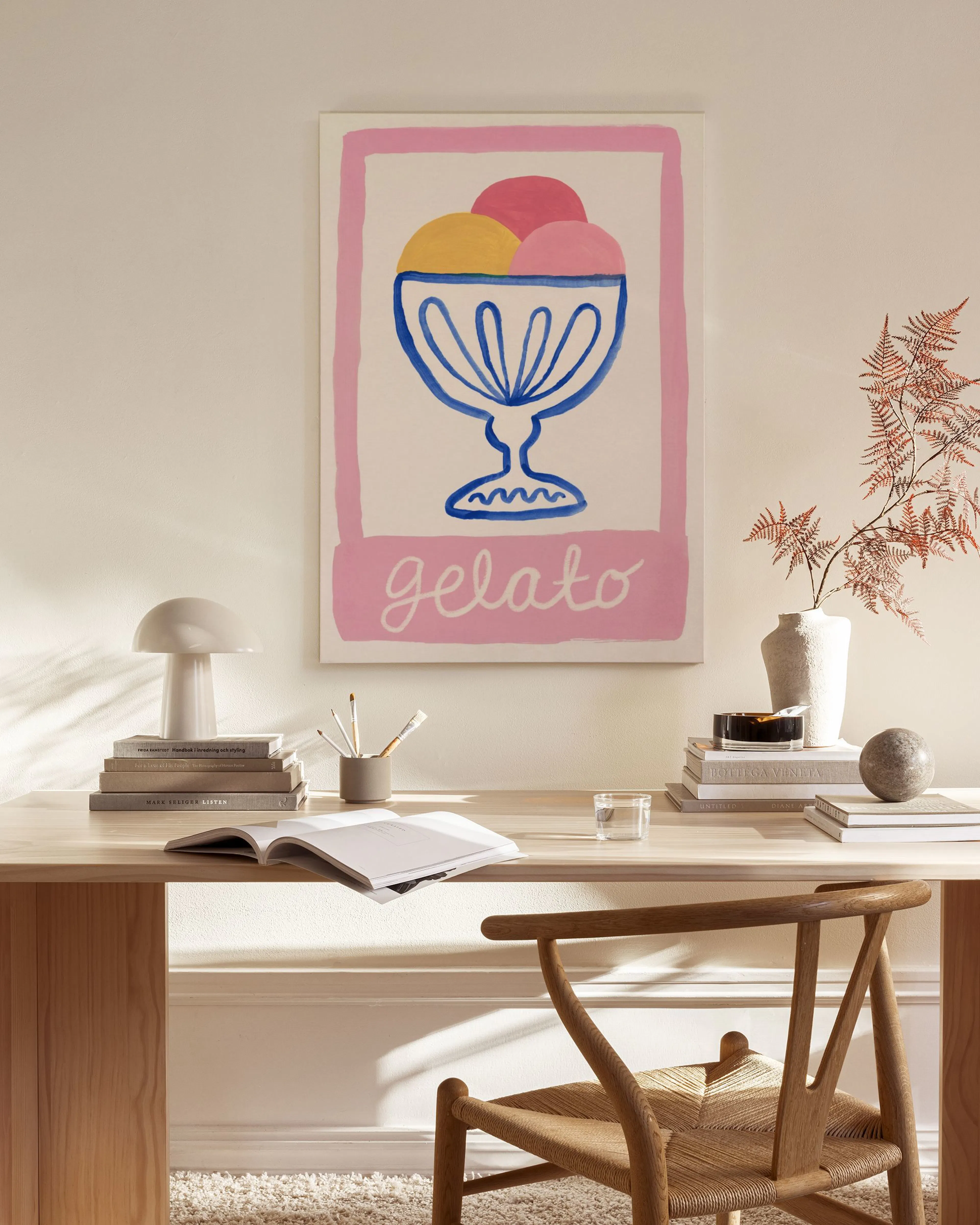 A vibrant gelato print with pink, yellow, and blue scoops in a bowl, hanging in a bright living room.