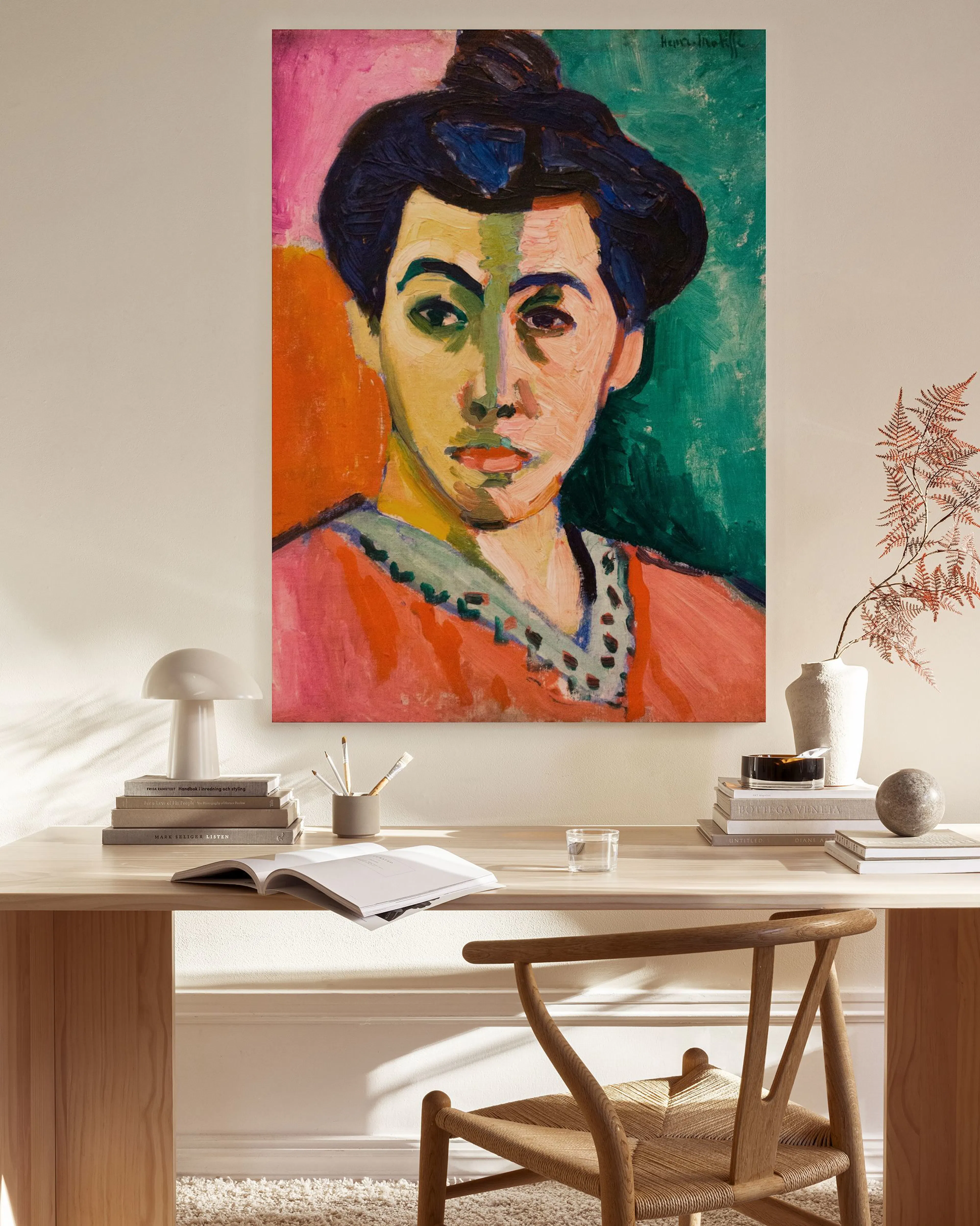 Tela decorativa com retrato de mulher de chapéu escuro, túnica rosa e fundo verde/rosa, em sala de estar moderna.