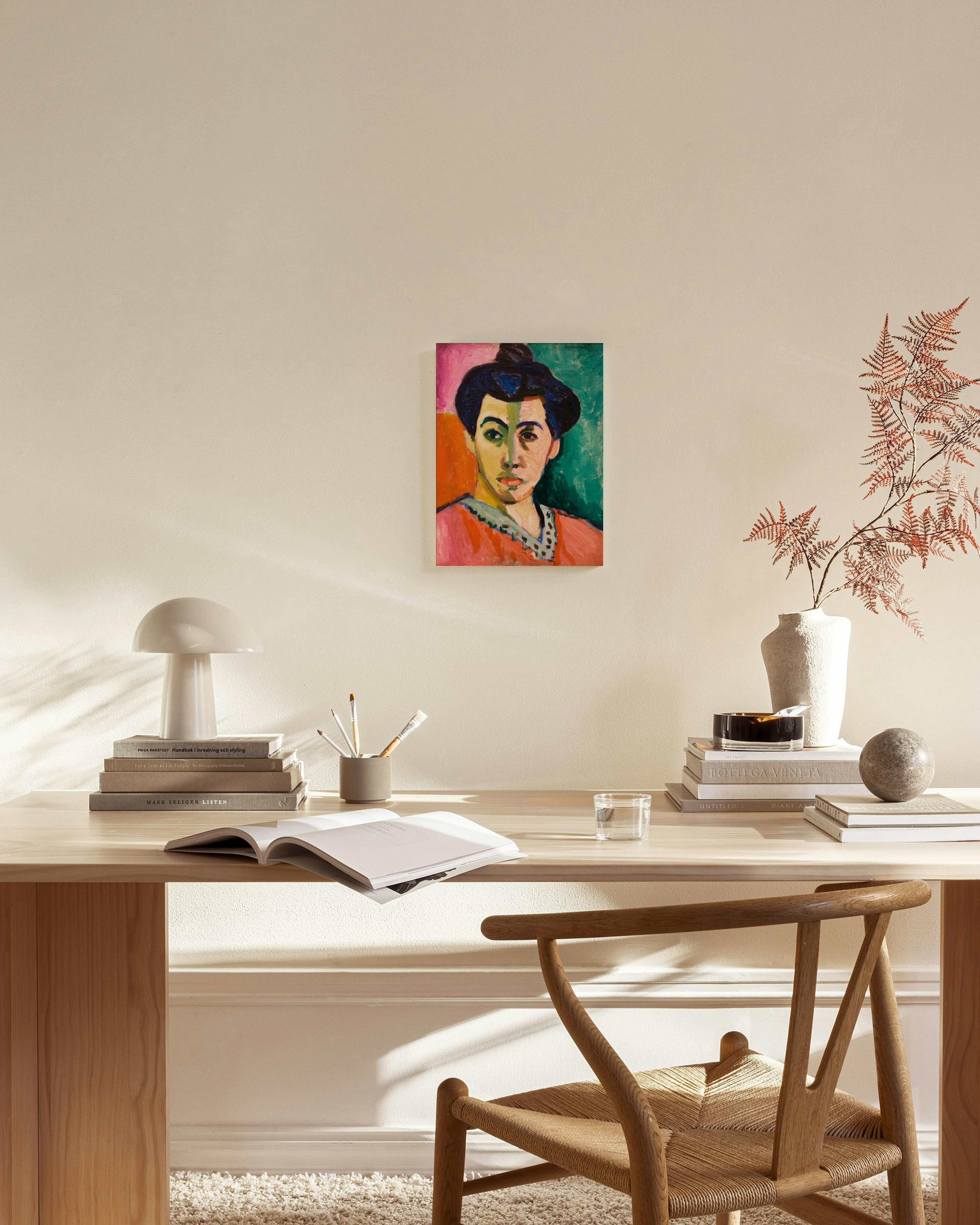 Toile dun portrait coloré dans le style Matisse, avec fond rose et vert, accrochée dans un salon moderne et lumineux.