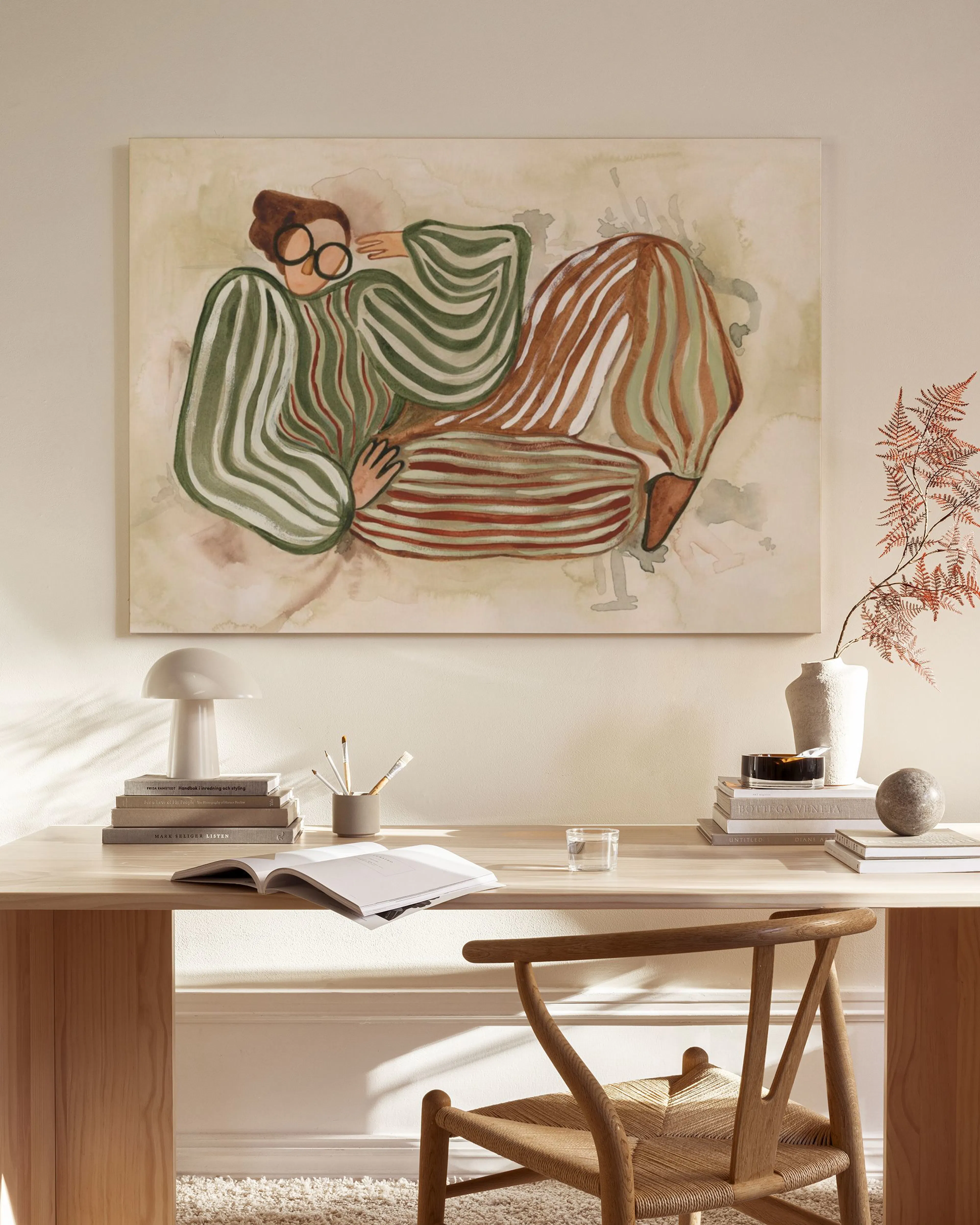 Leinwandbild einer sitzenden Person mit grünen und braunen Streifen, über einem Sideboard in einem modernen Wohnzimmer.