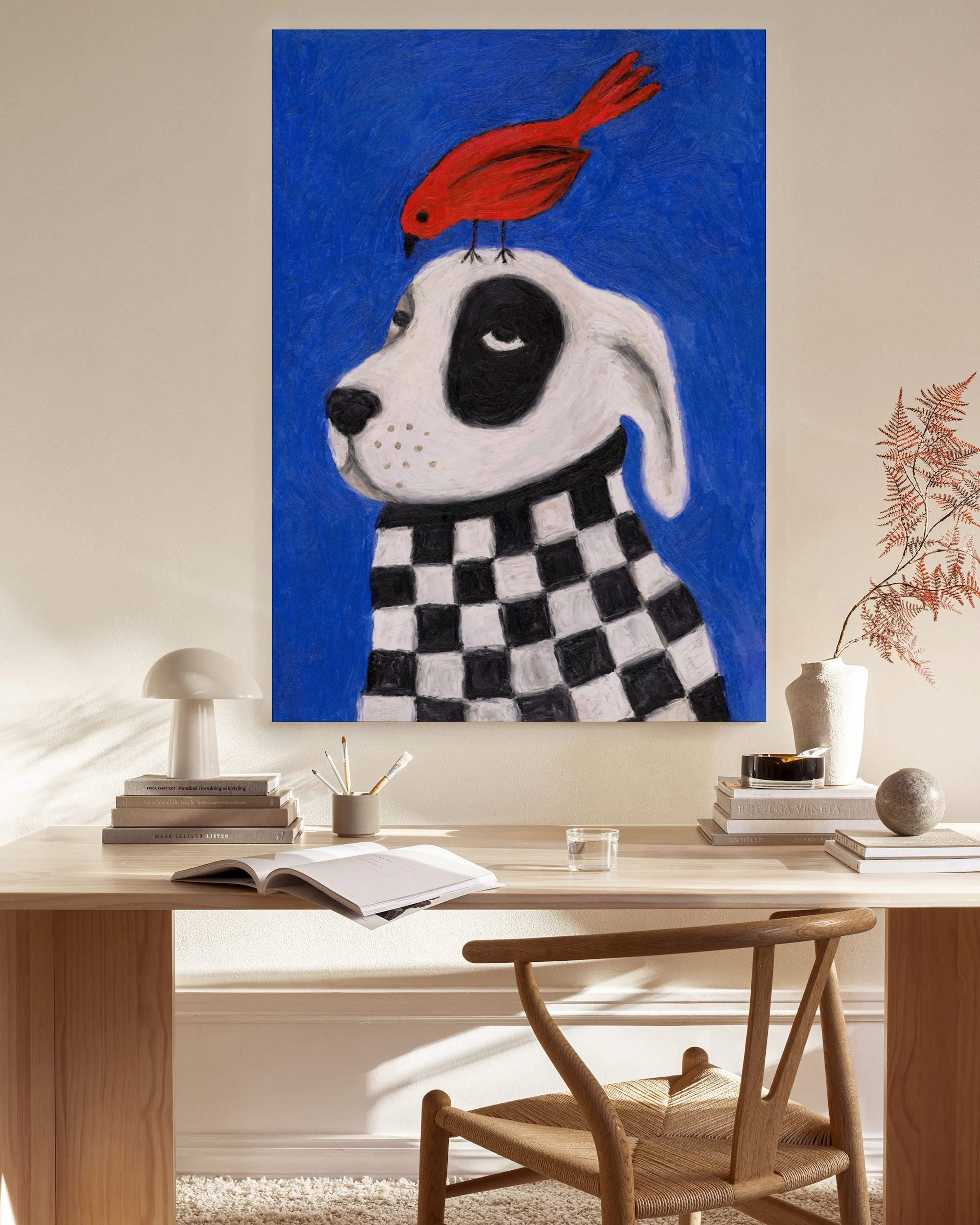 Leinwandbild: Hund mit schwarz-weißem Pullover und rotem Vogel auf dem Kopf, an einer Wand im Wohnzimmer.