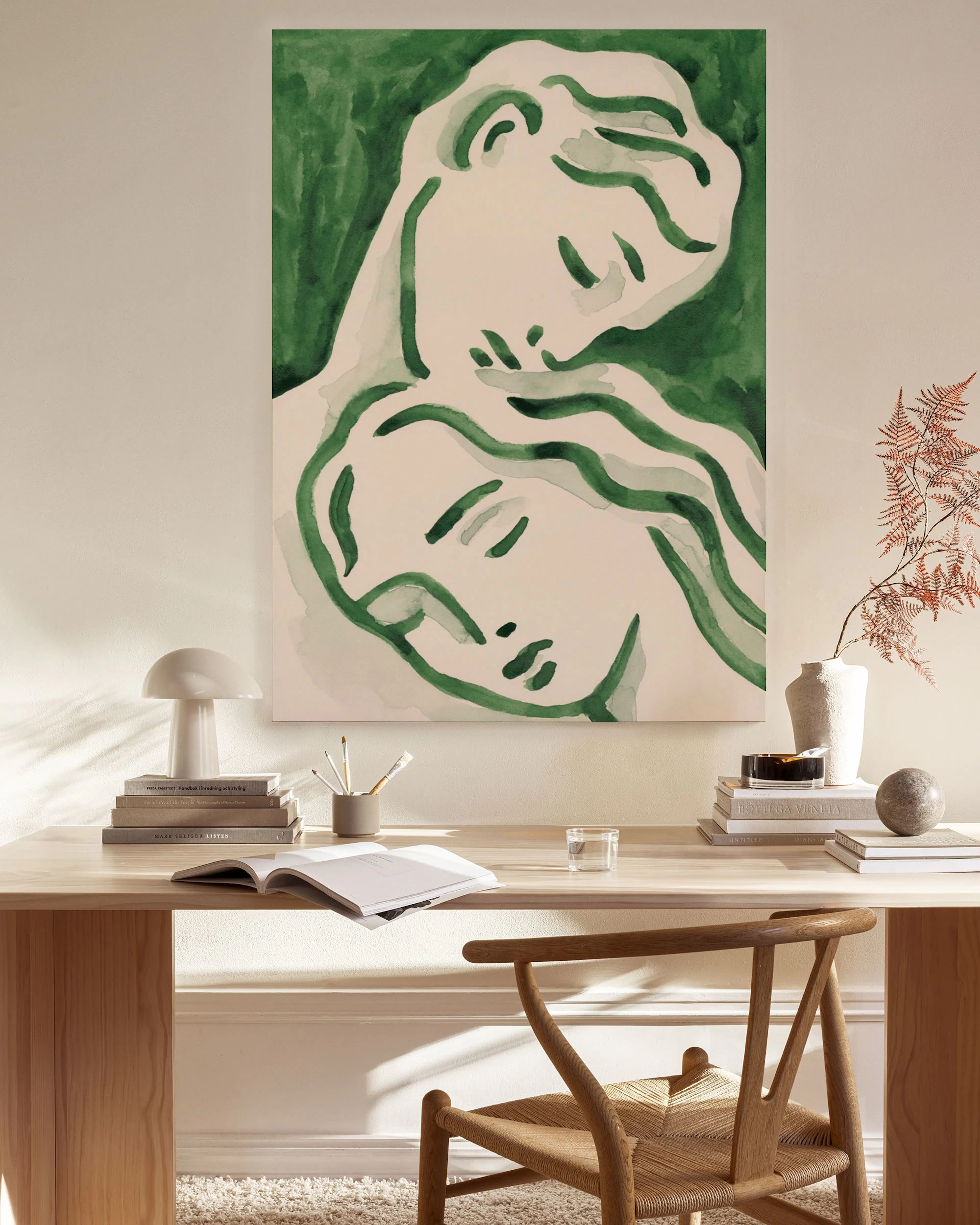 Toile murale abstraite verte avec deux visages entrelacés, accrochée dans un salon moderne.
