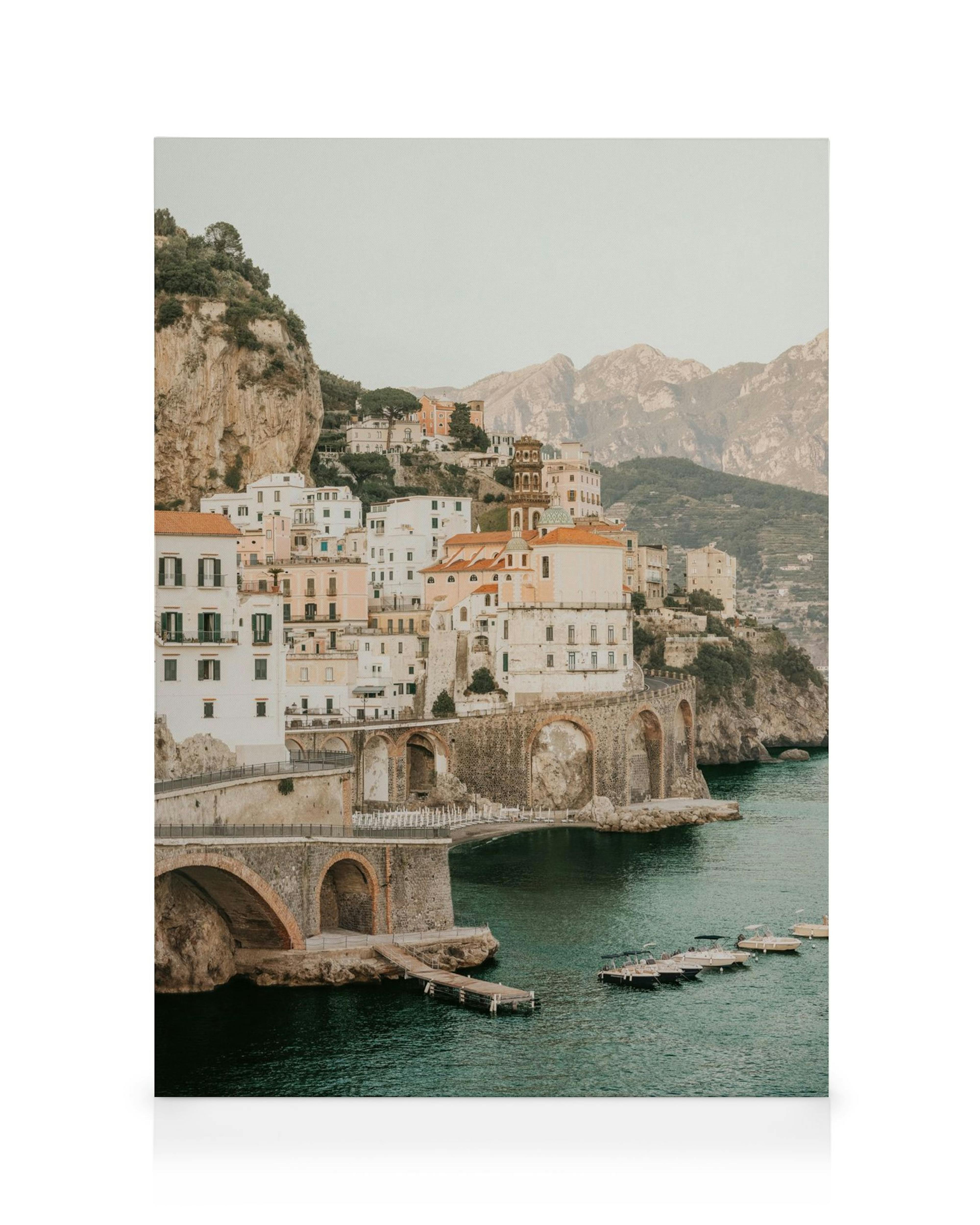 Lærred med udsigt over Amalfi-kysten, Italien. Hvide huse med røde tage og buegange ved kysten og bjerge i baggrunden.