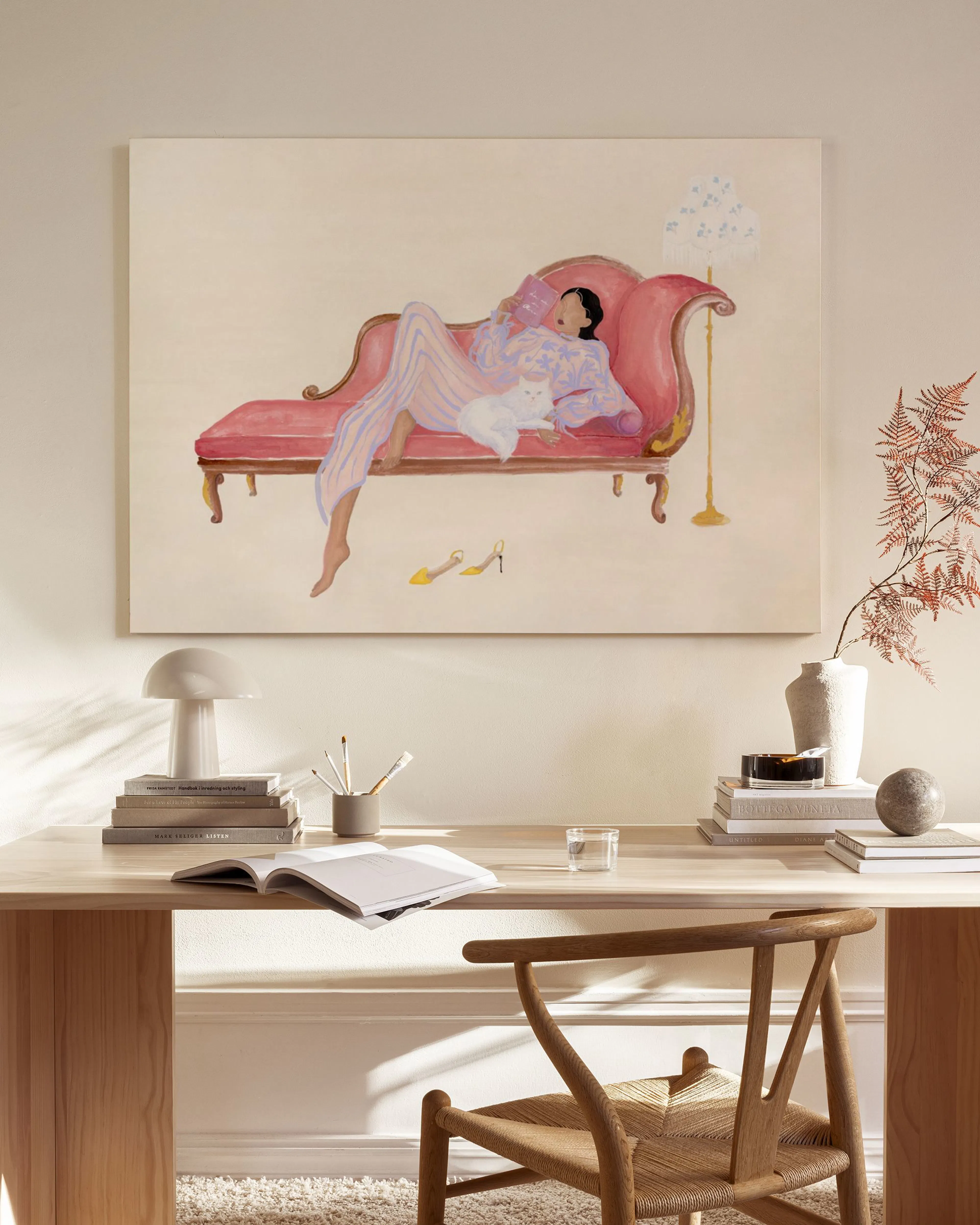 Leinwandbild einer Frau in rosa Pyjama auf einer Chaiselongue, hängend in einem modernen Wohnzimmer über einem Sideboard.