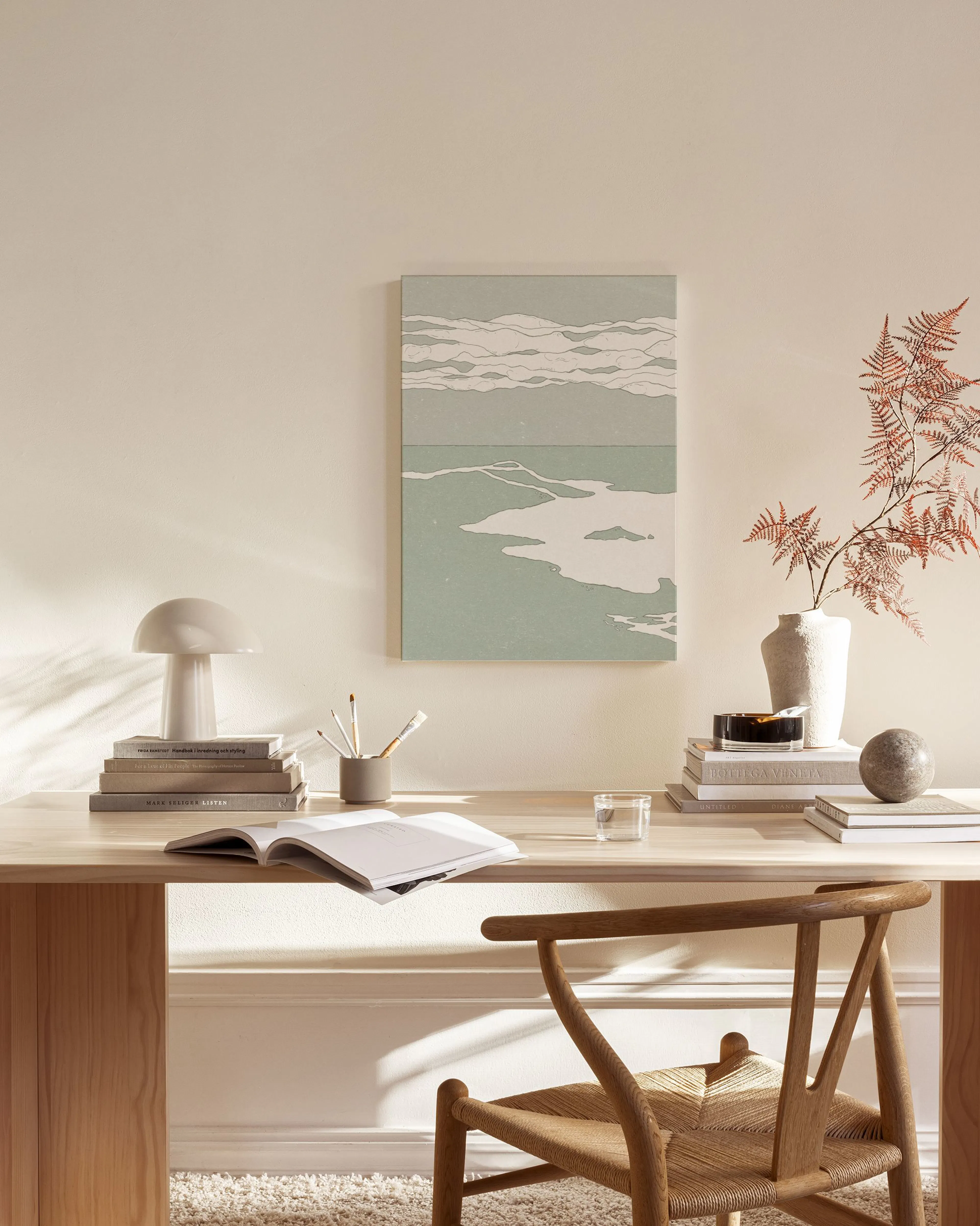 Canvas met een lichtgroen landschap met witte, golvende lucht en water, hangend in een neutrale woonkamer.