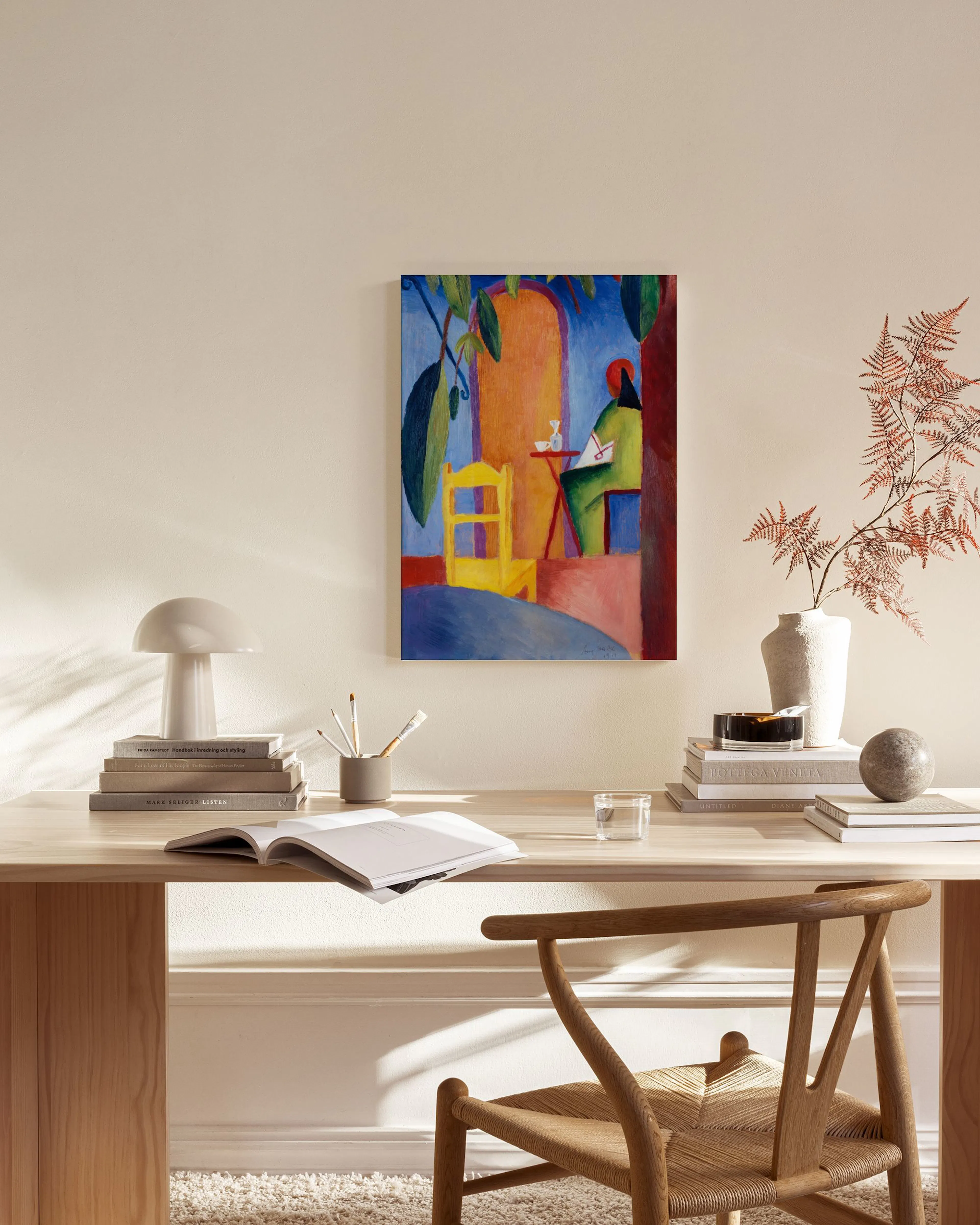 Colorful expressionist painting of a person sitting at a table outdoors, hanging in a modern living room.