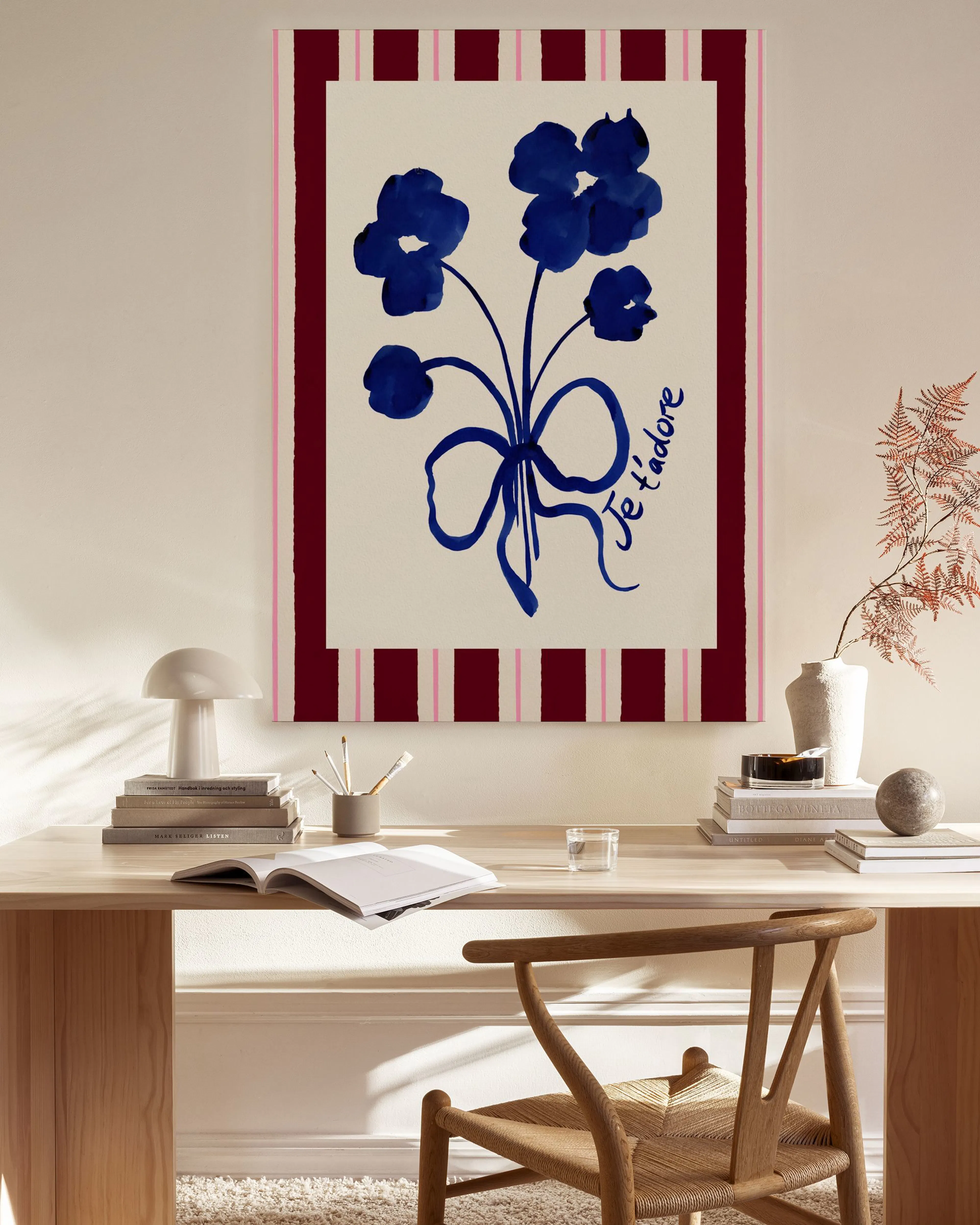 Stampa su tela con fiori blu e fiocco, sfondo a righe rosse, esposta in un soggiorno moderno.