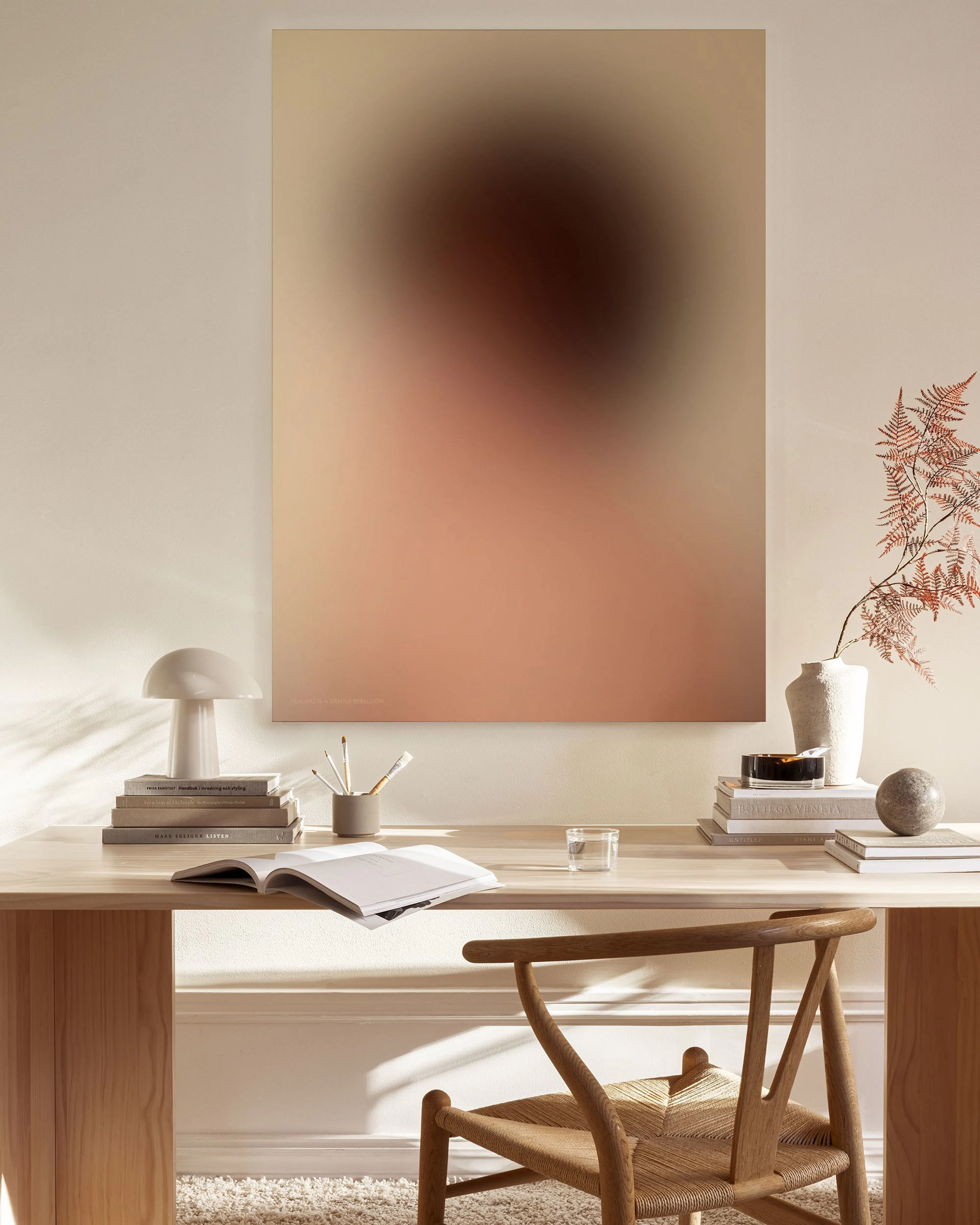 A blurred portrait print with warm beige, brown, and pink tones, hanging above a timber console table in a minimalist living roo