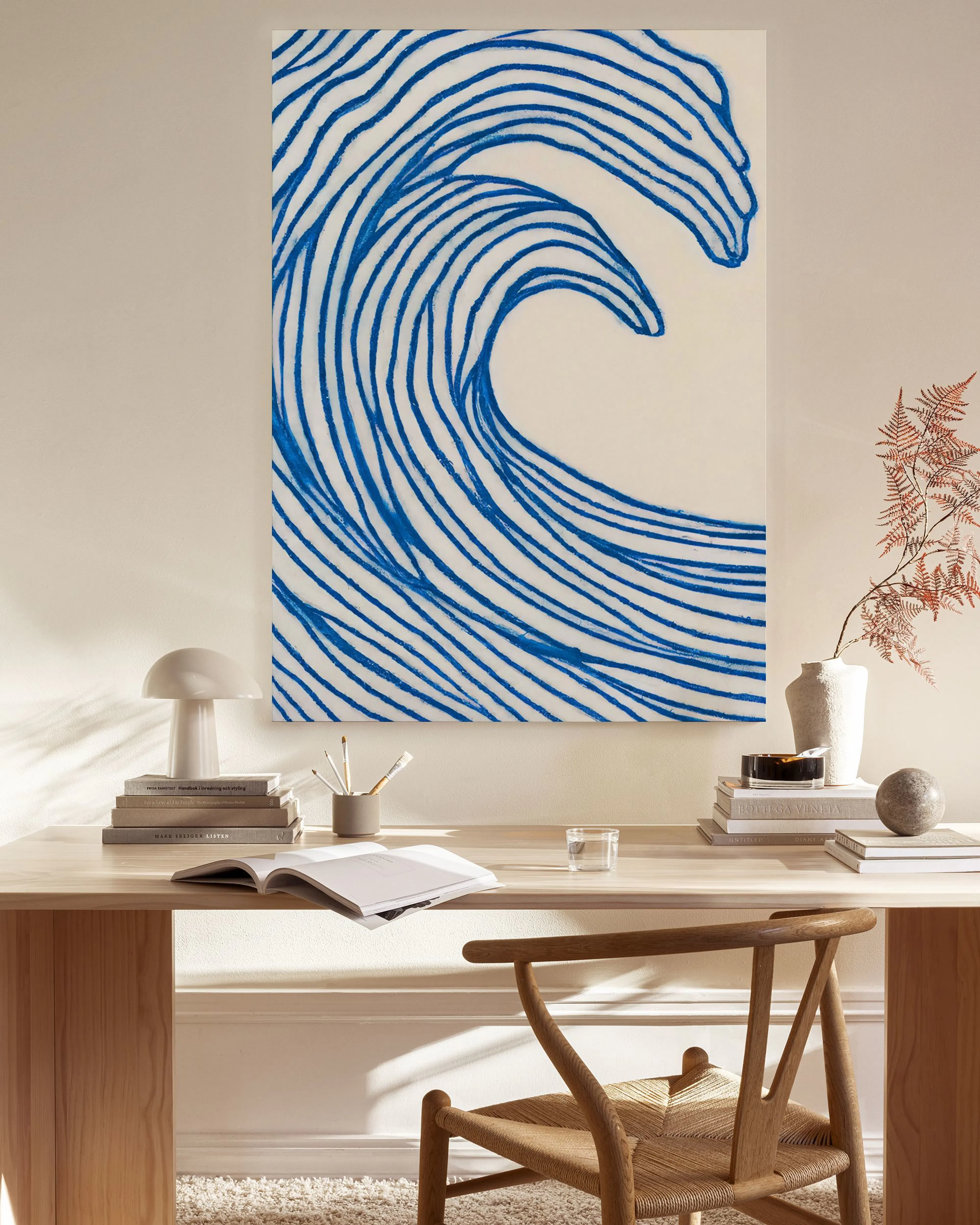 Toile murale, vague bleue stylisée sur fond clair, suspendue au-dessus dun banc en bois dans un salon moderne.