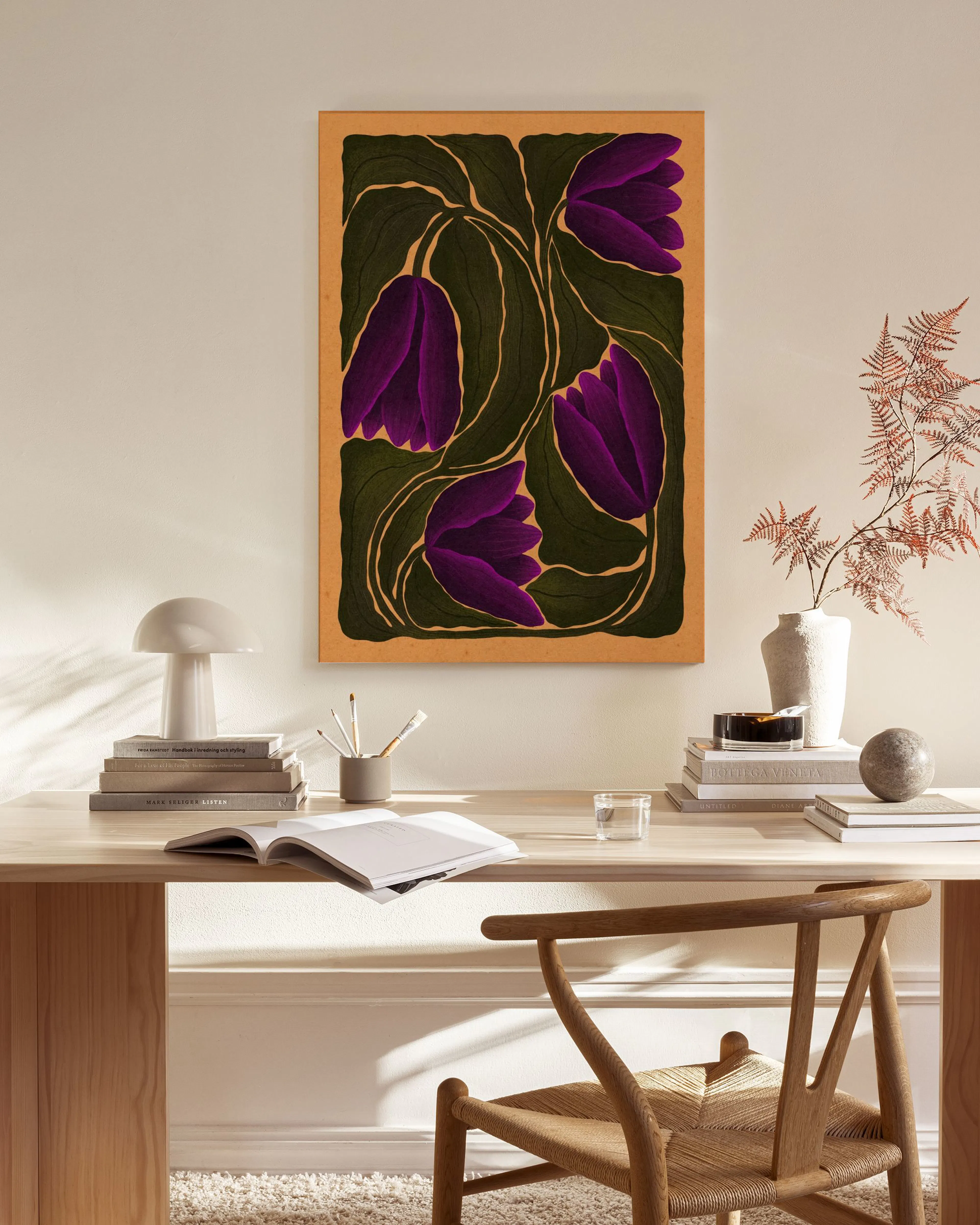 Canvas print with deep purple floral patterns and dark green leaves, displayed on a light wall in a minimalist living room.