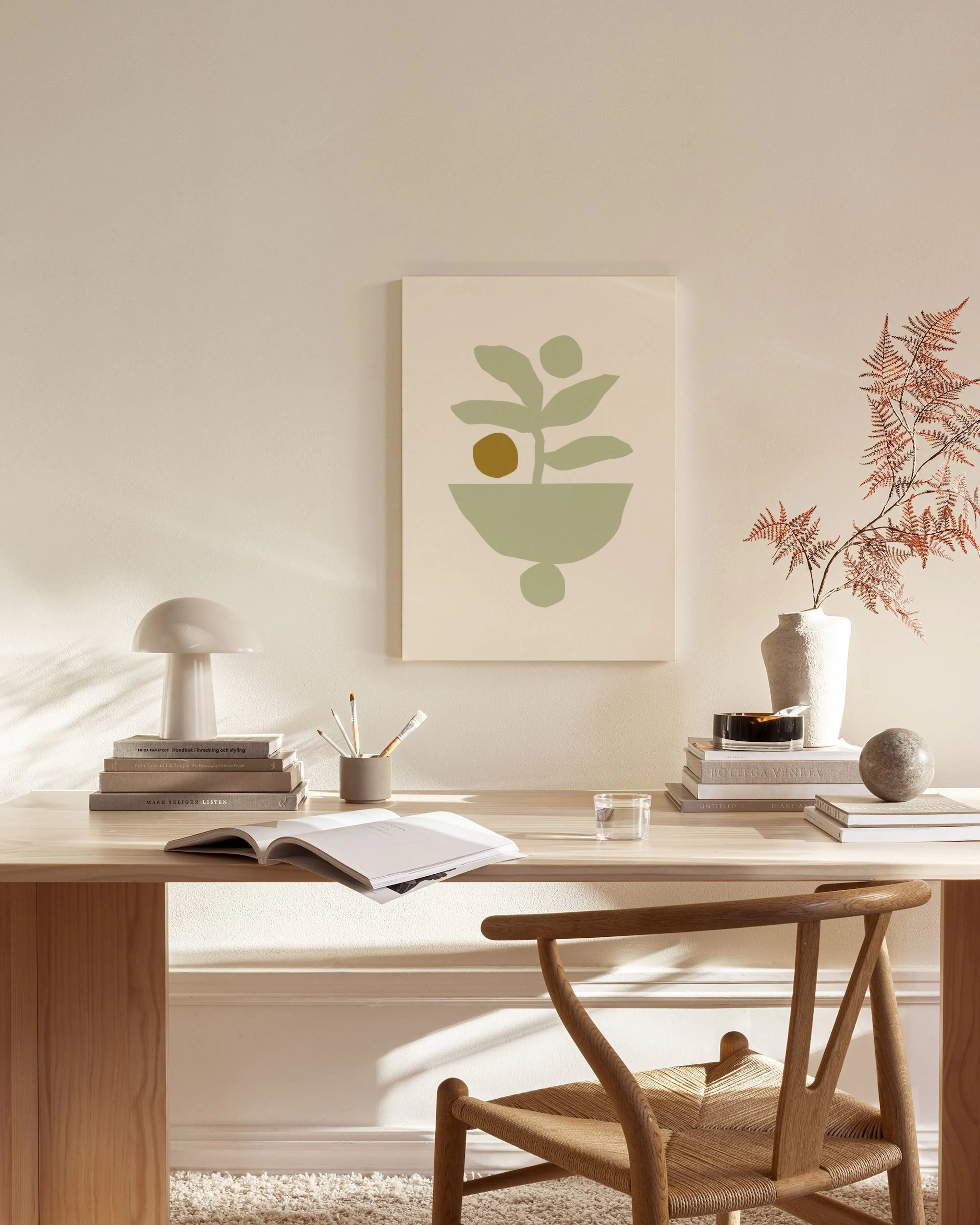 Toile murale abstraite avec formes végétales vert pâle et cercle ocre, affichée dans un salon moderne aux tons neutres.