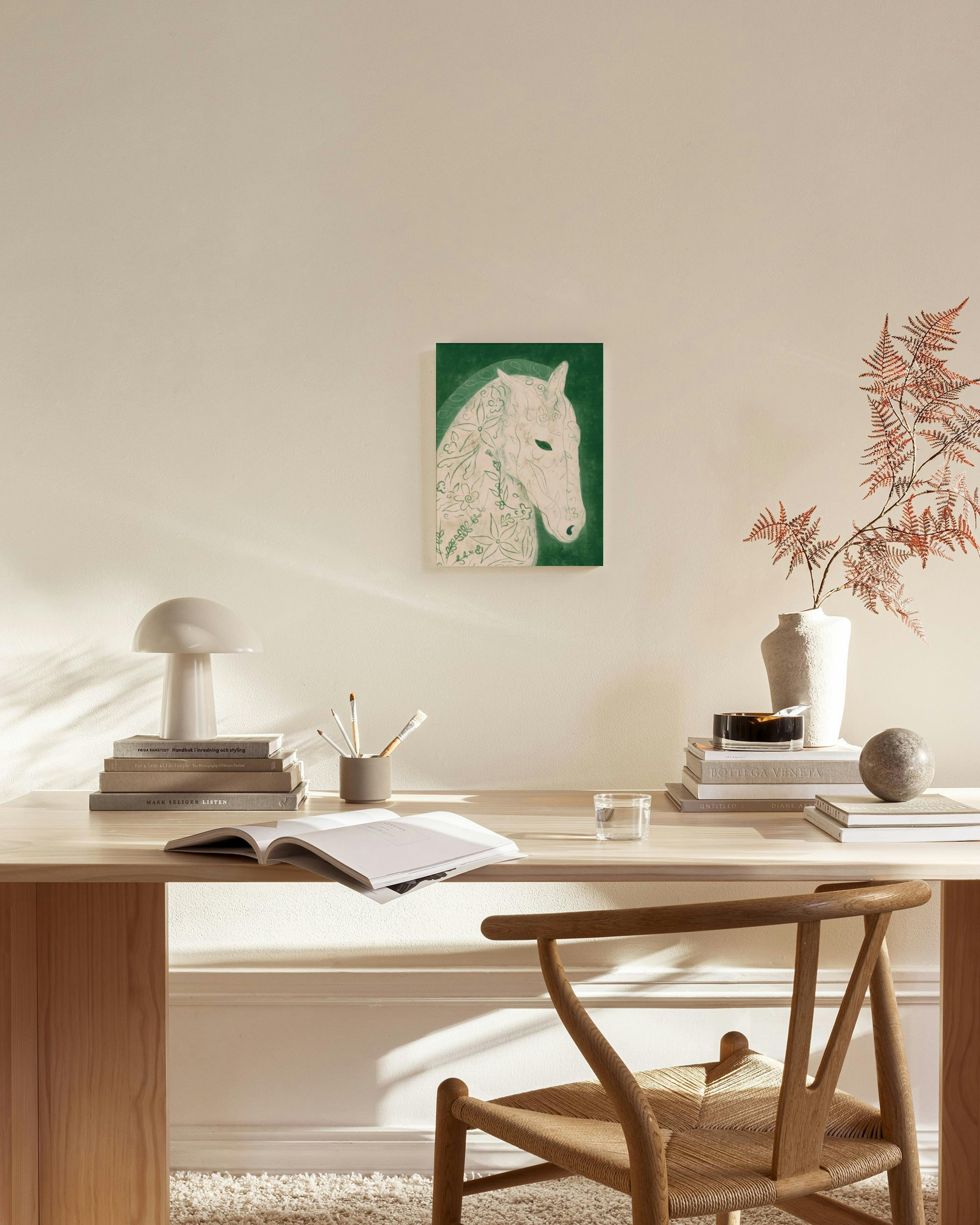 Stampa su tela di cavallo con motivi floreali su sfondo verde, appesa in un soggiorno moderno.