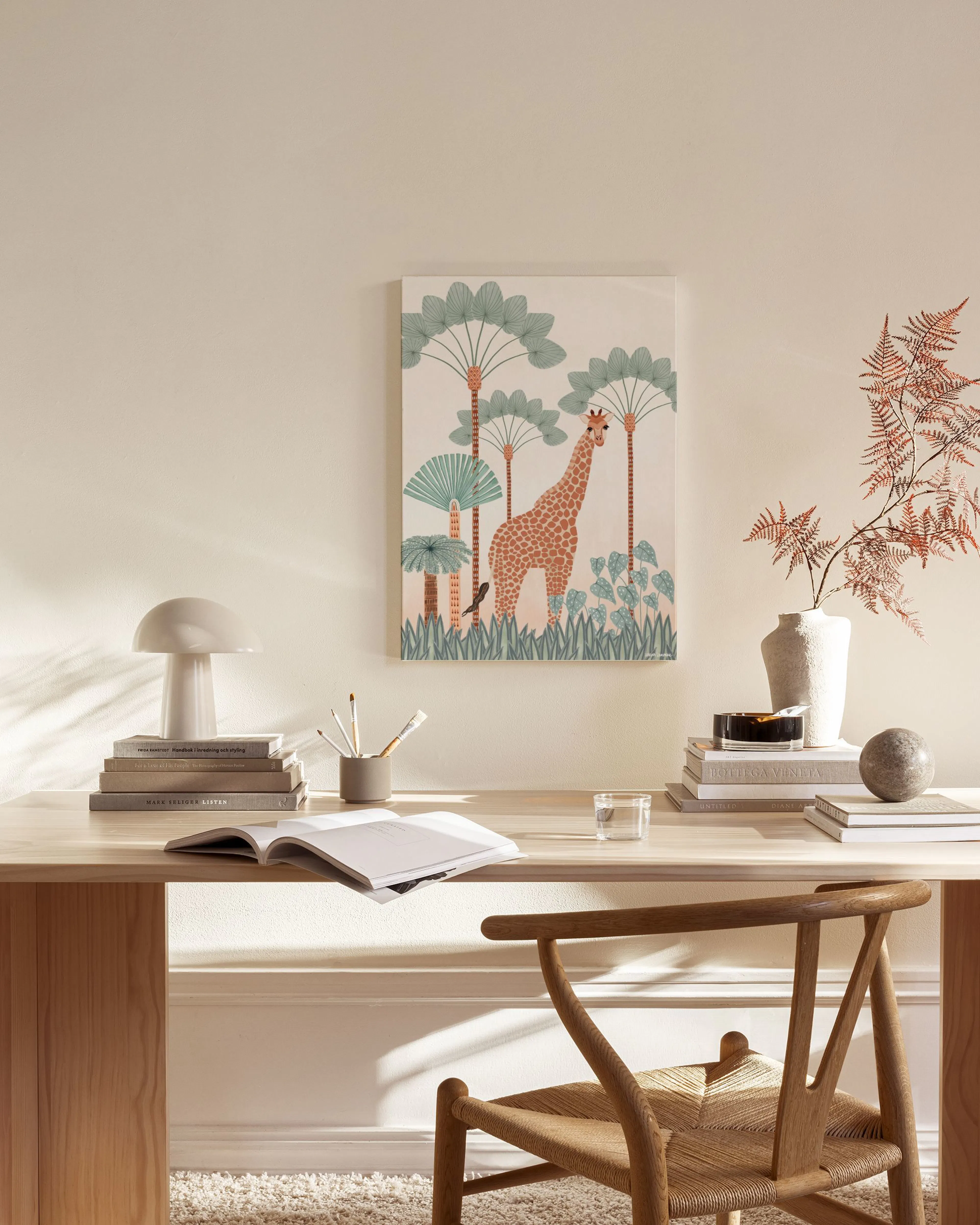 Canvas met een giraf tussen palmbomen en planten, hangend in een neutrale woonkamer boven een houten dressoir.