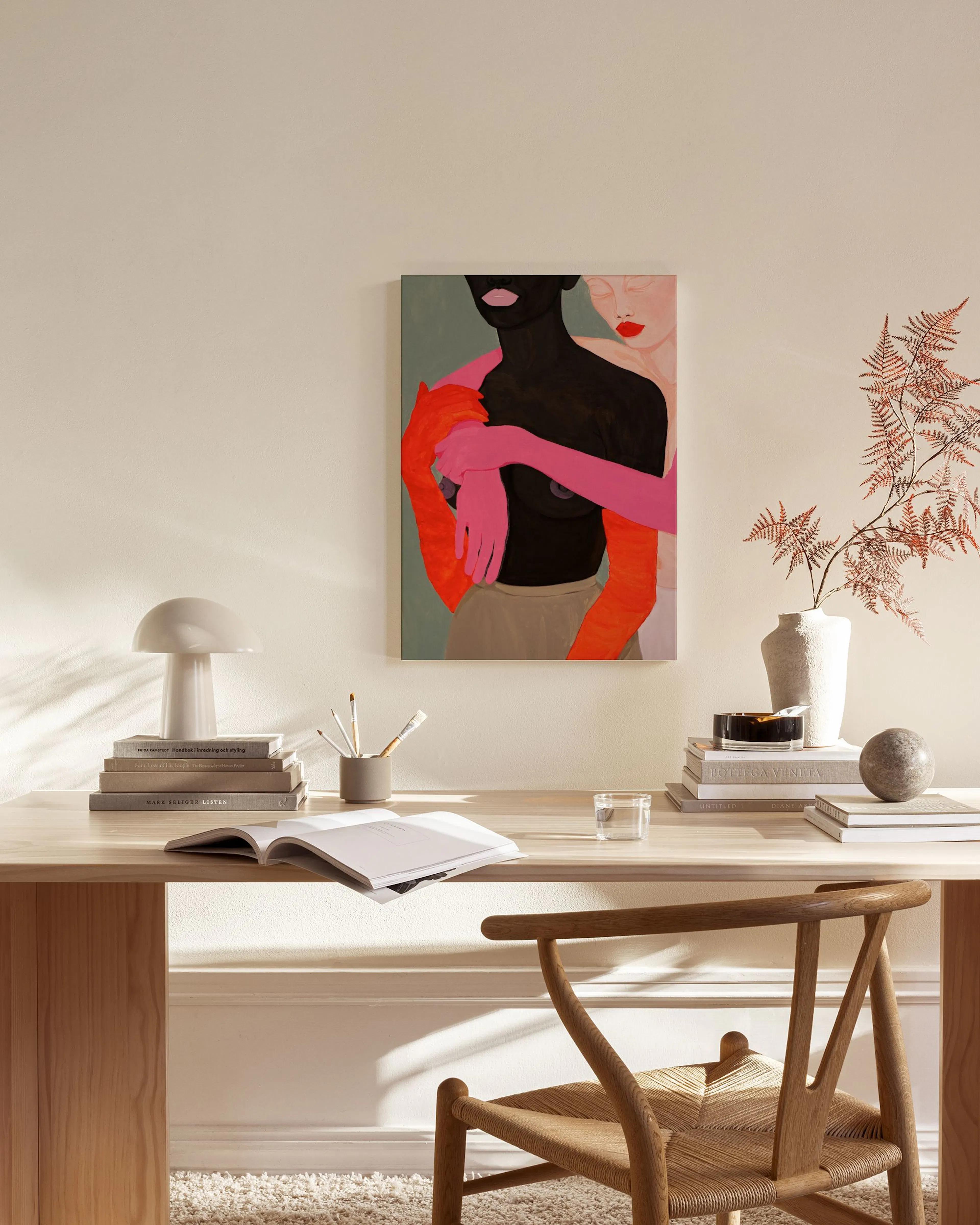Leinwandbild mit Umarmung zweier Figuren in bunten Farbtönen, hängend über einem Sideboard in einem Wohnzimmer.