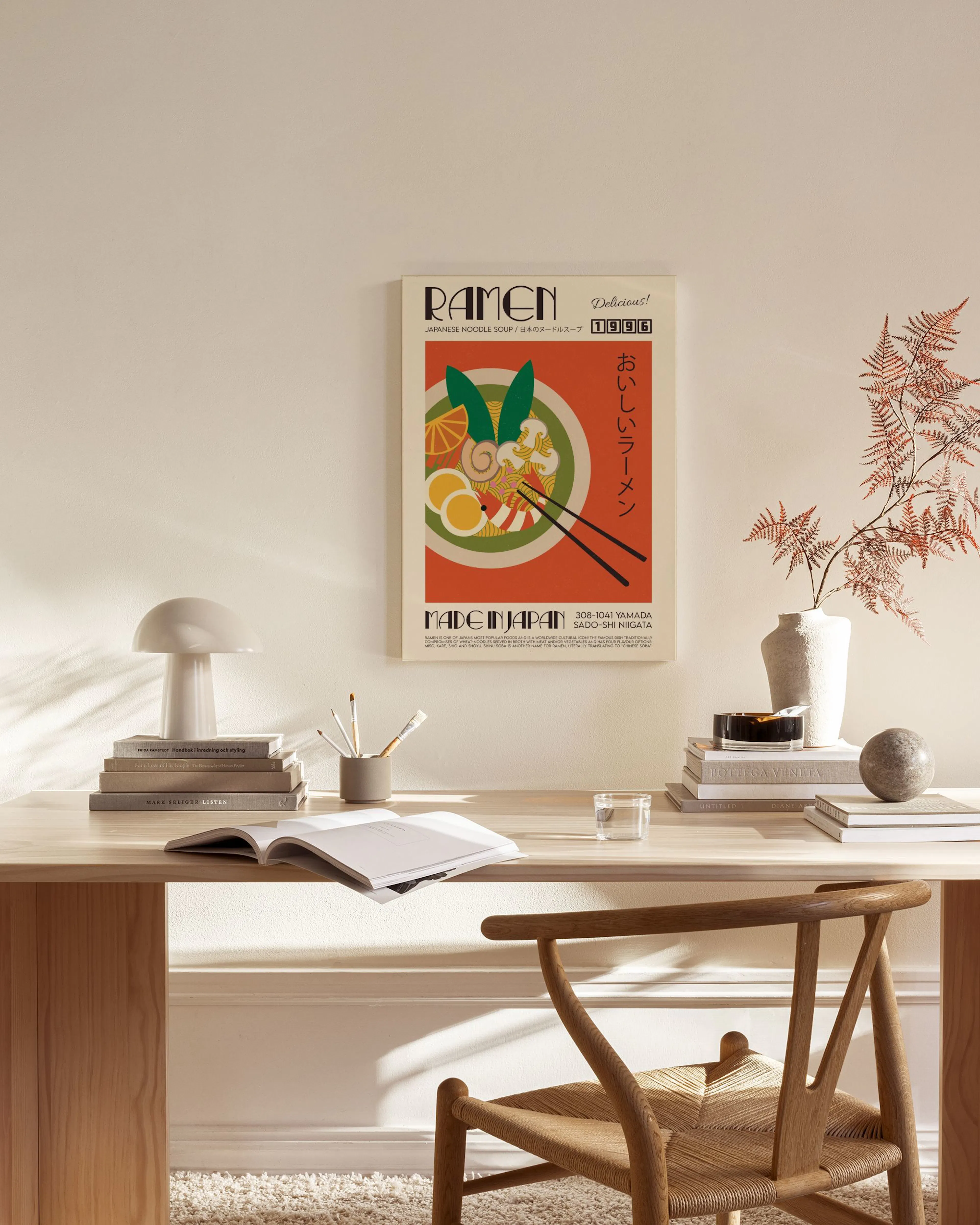 A colorful ramen bowl poster with text in Japanese and English, hanging in a minimalist living room.
