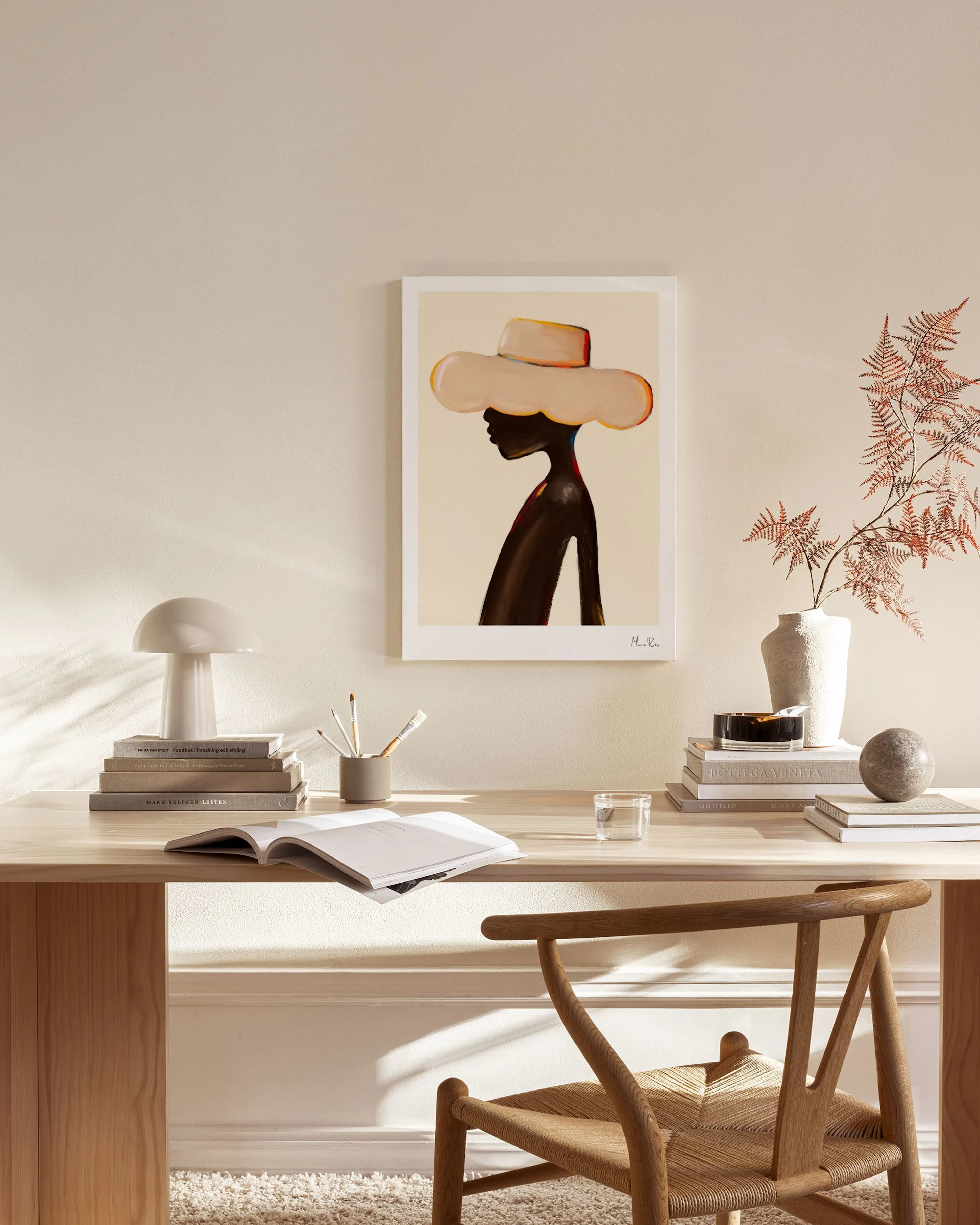 Stampa su tela di una donna con un cappello chiaro, appesa in un soggiorno moderno con mobili in legno.