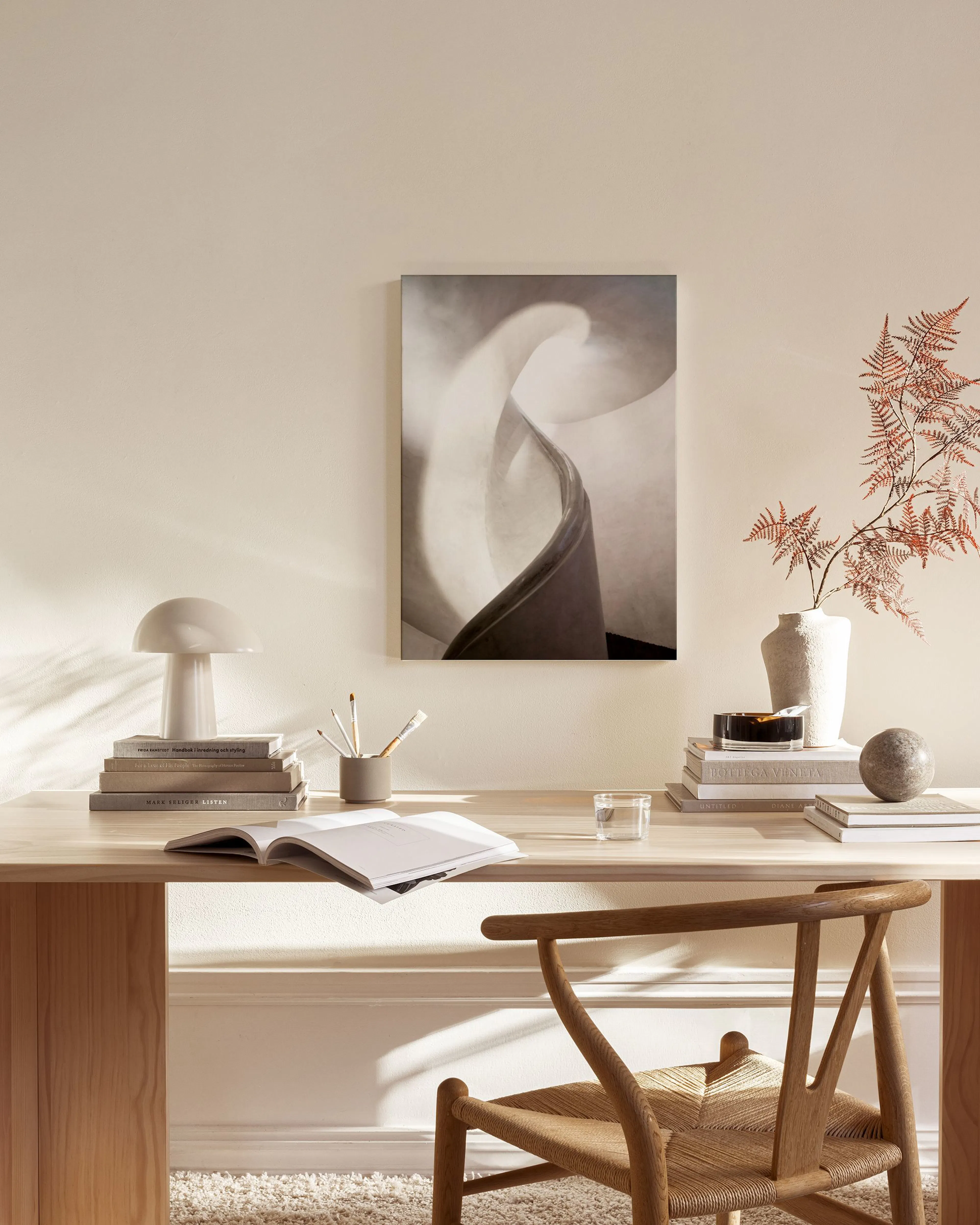 Leinwandbild mit abstrakten, weichen Formen in Grau- und Beigetönen, hängt in einem modernen Wohnzimmer über einem Sideboard.