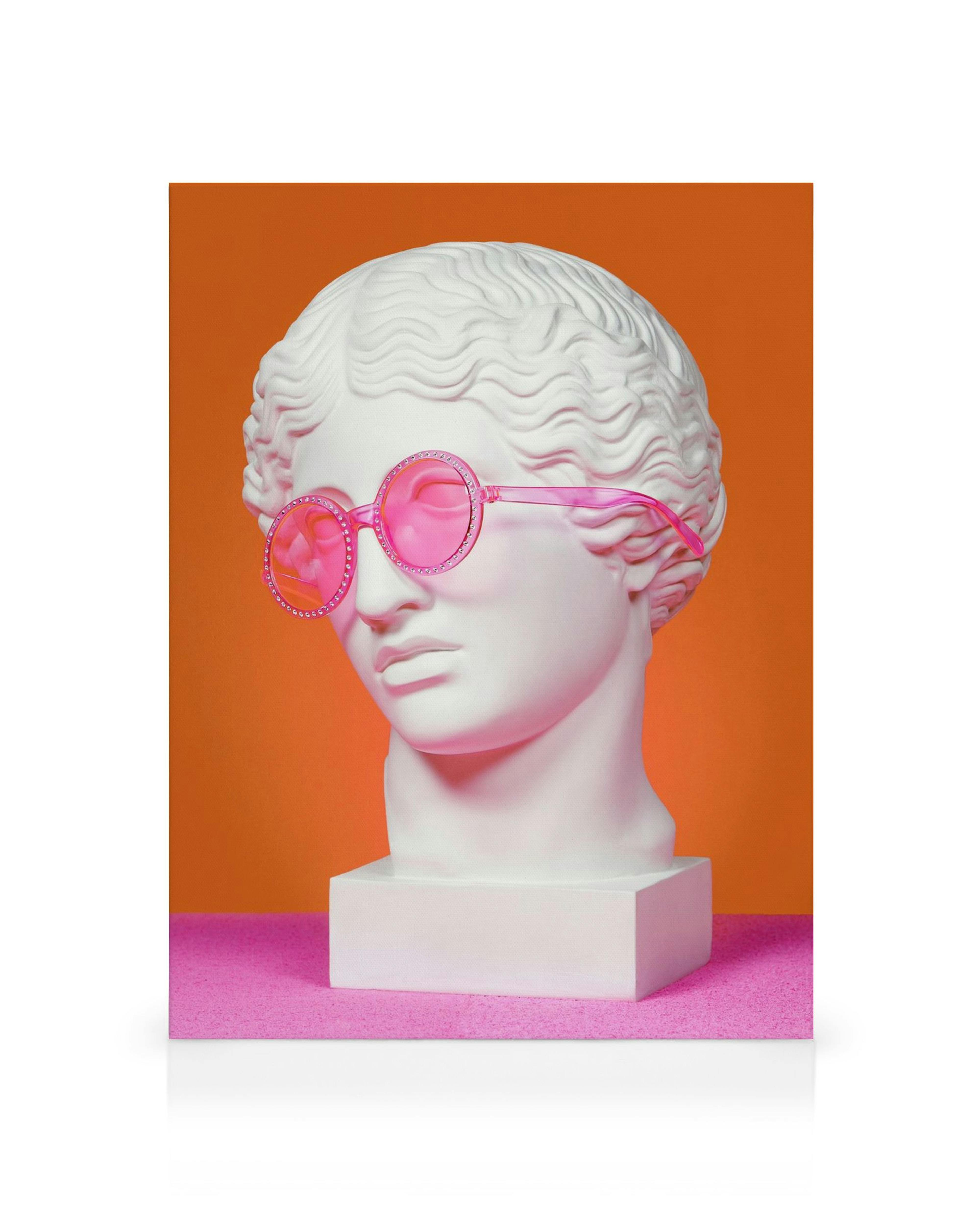 White Greek God bust with pink round glasses, on a pink surface with an orange background modern art canvas.