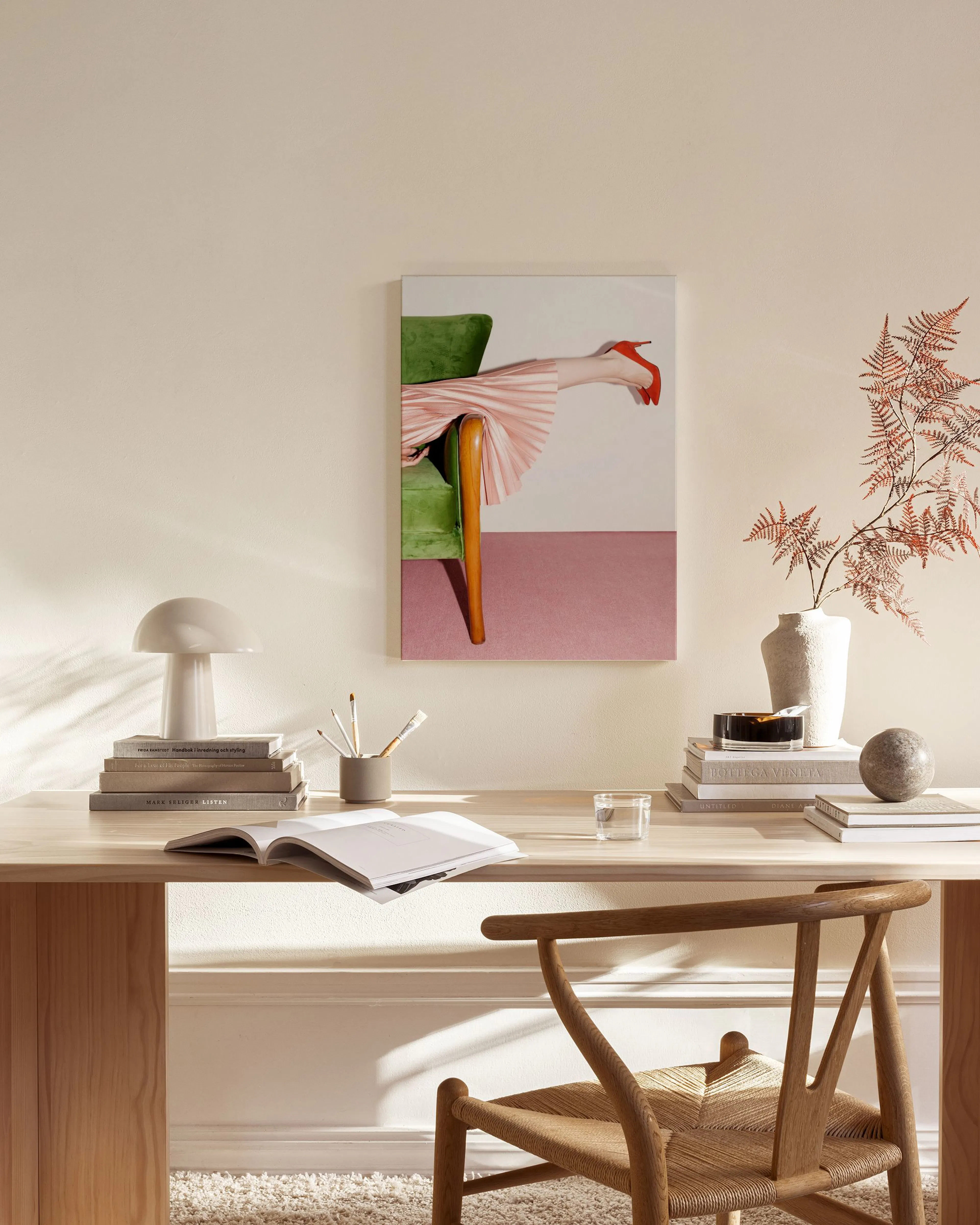 Lienzo con pierna de mujer en falda plisada rosa y zapatos rojos, asomando de un sillón verde en un salón moderno.