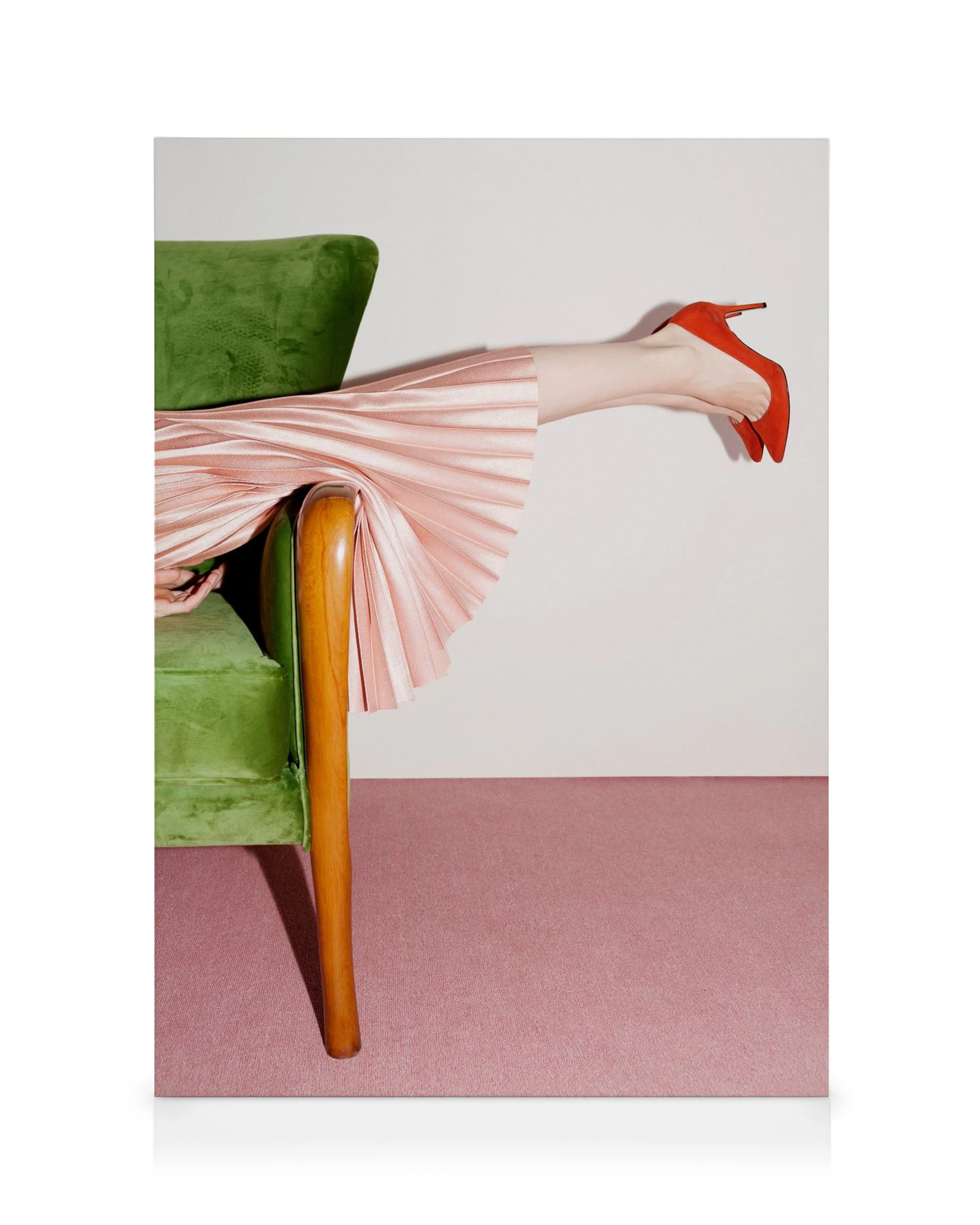Piernas cruzadas con zapato rojo, falda plisada rosa y silla verde sobre alfombra rosa. Arte vibrante.