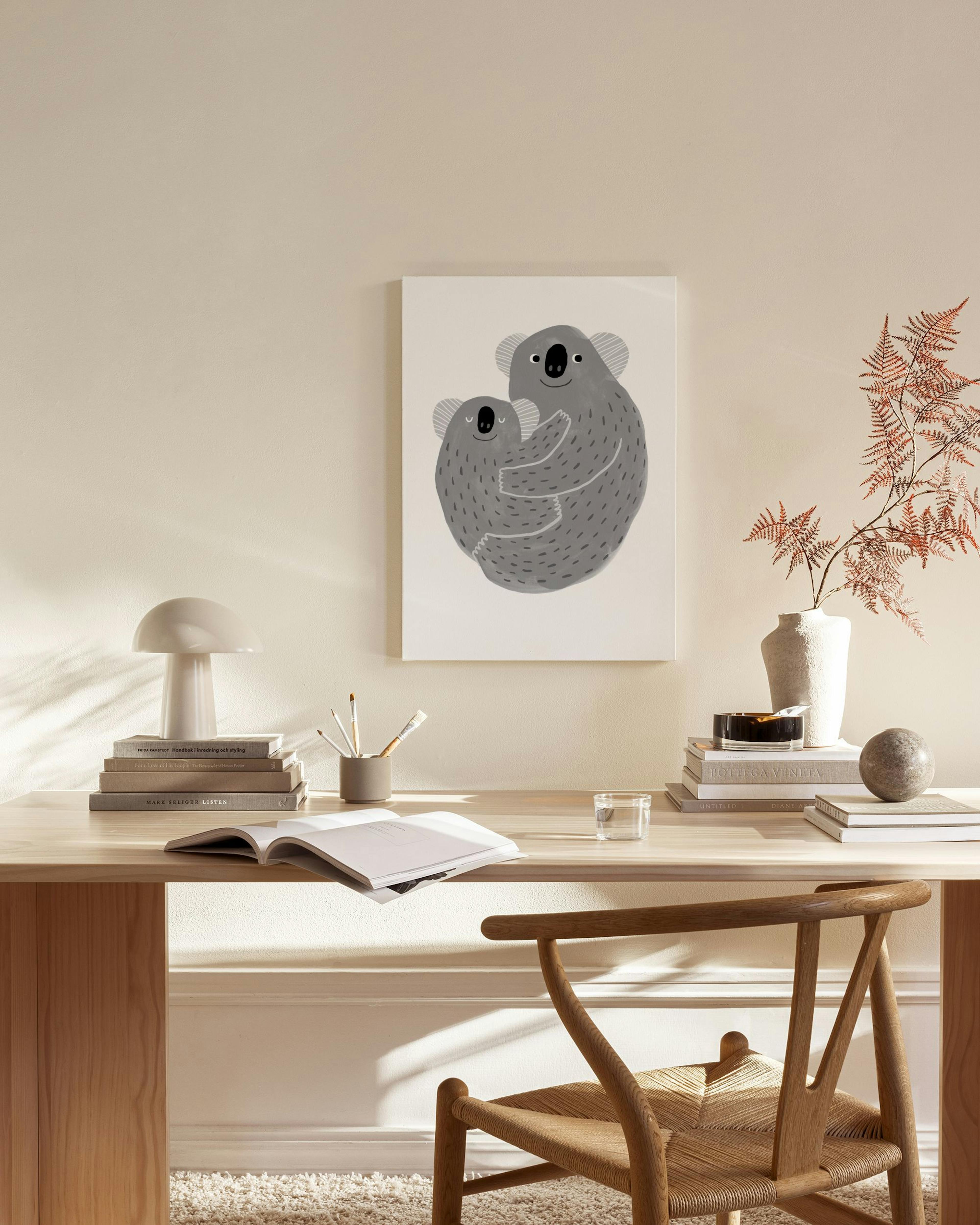 Stampa su tela con due koala grigi che si abbracciano, appesa sopra una panca in un salotto moderno.