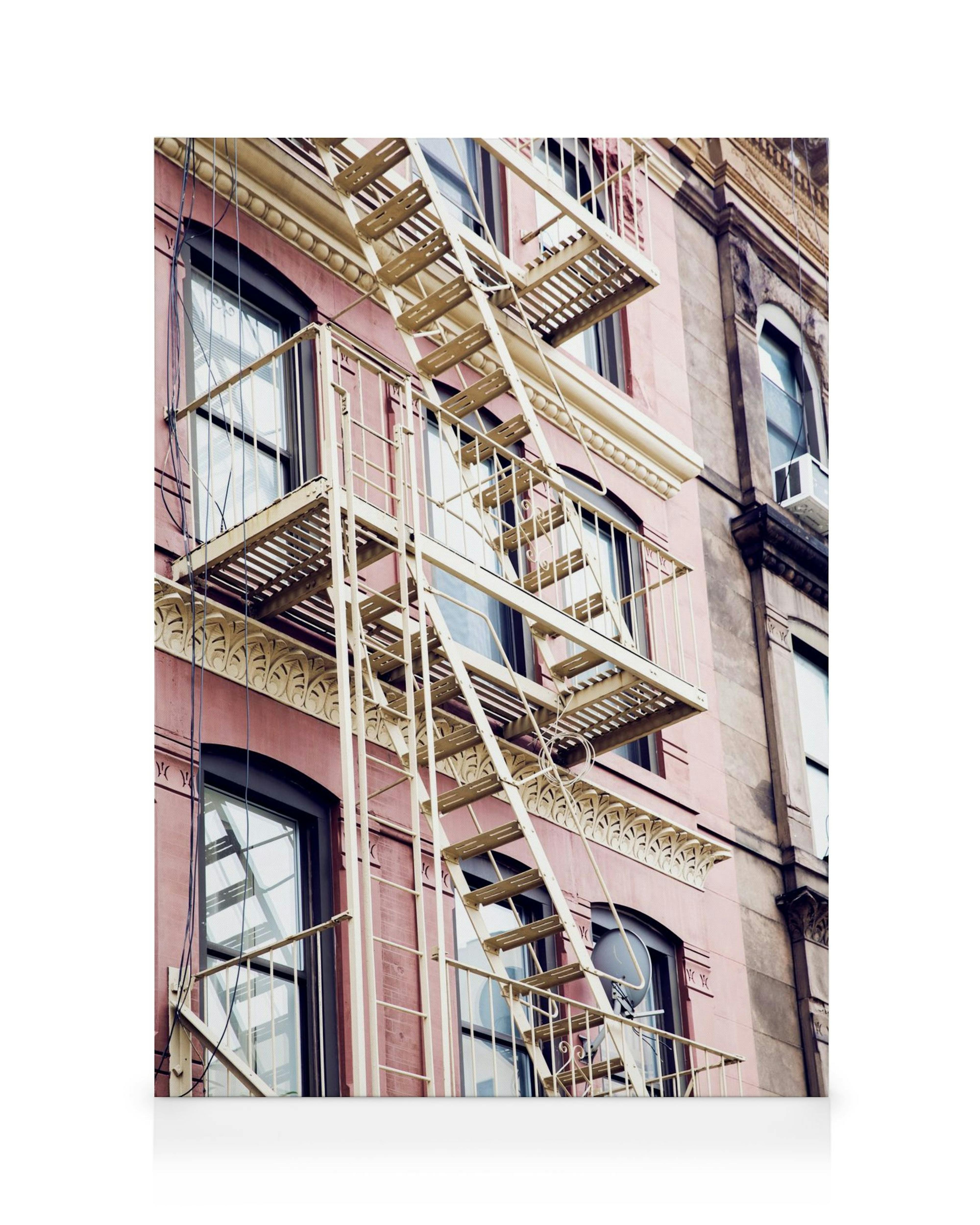Pink building with cream fire escape and multiple windows, urban architecture canvas.