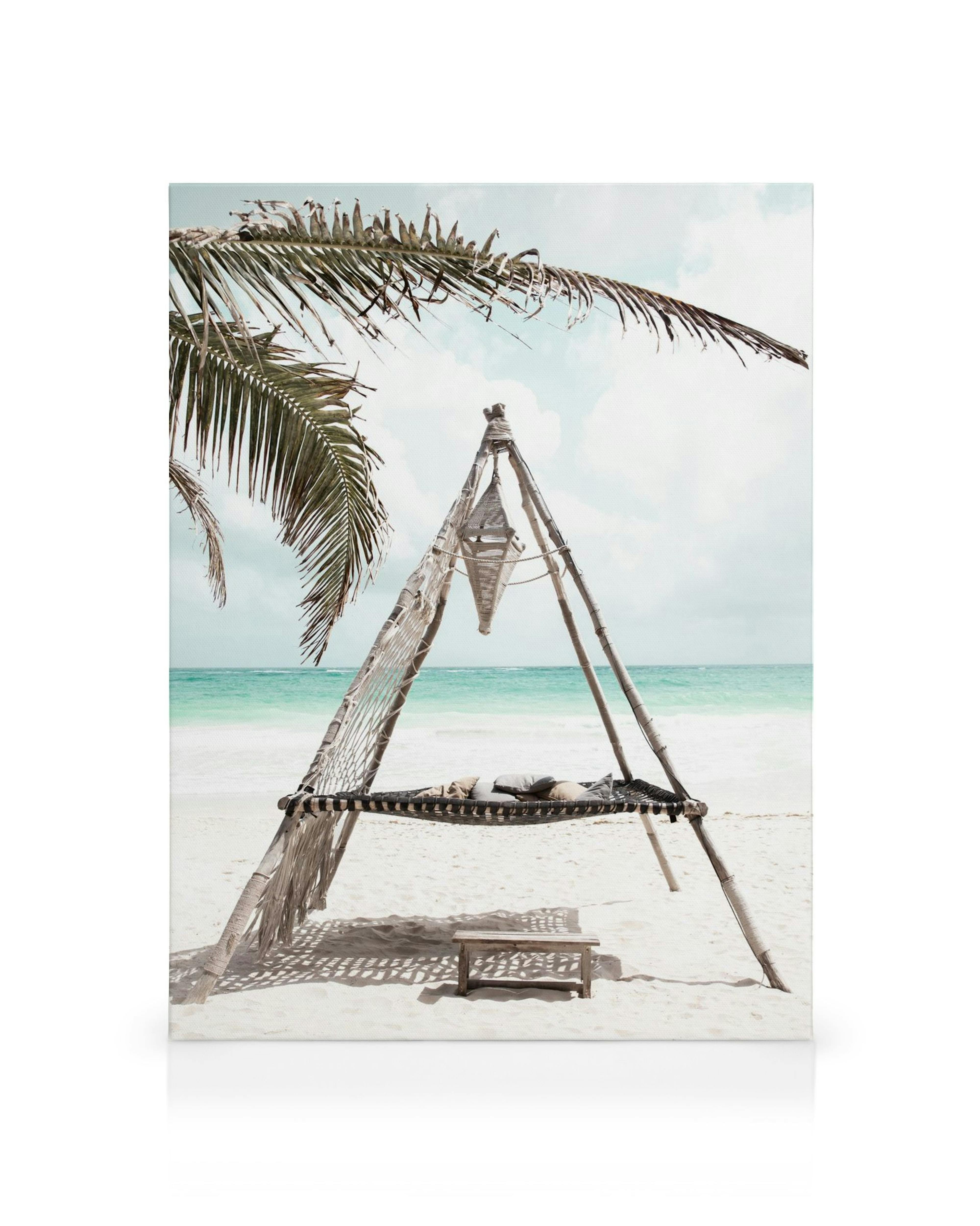 Outdoor hammock bed on white sand beach with palm tree and turquoise ocean horizon, tropical canvas print.