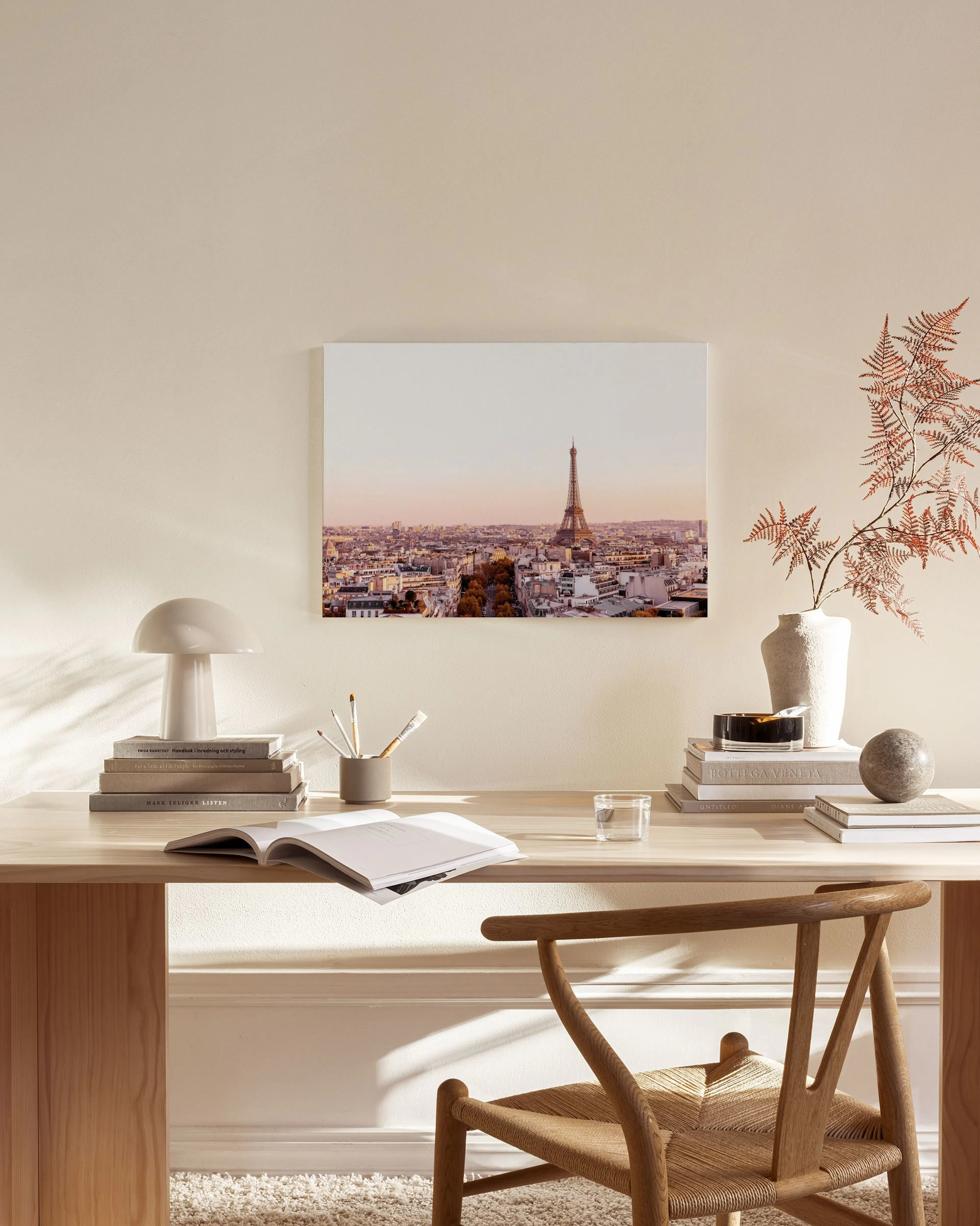 Leinwandbild der Pariser Skyline mit Eiffelturm bei Dämmerung, über einer Holzbank im Wohnzimmer.