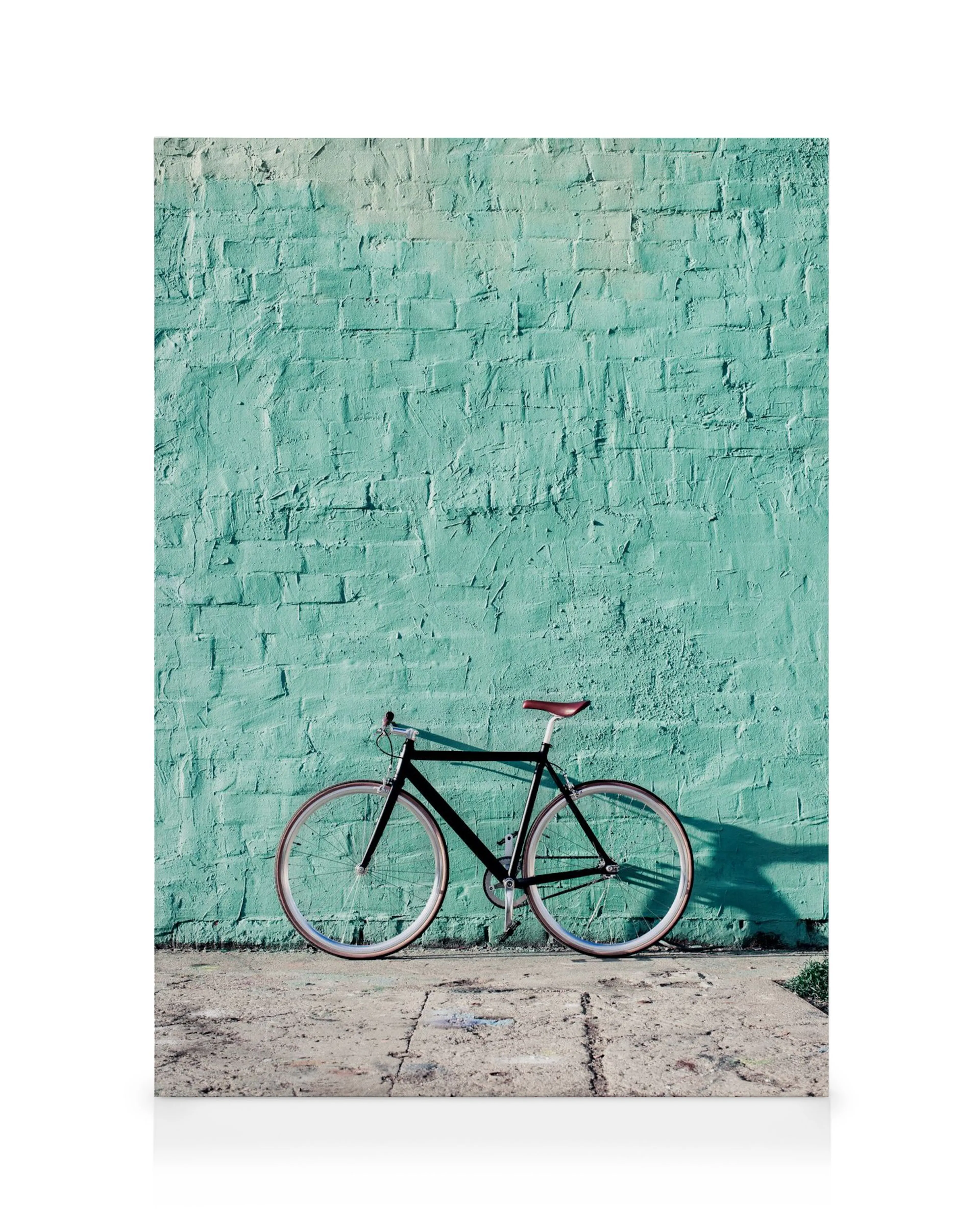 Toile avec bicyclette noire, roues brunes et selle rouge devant un mur turquoise texturé.