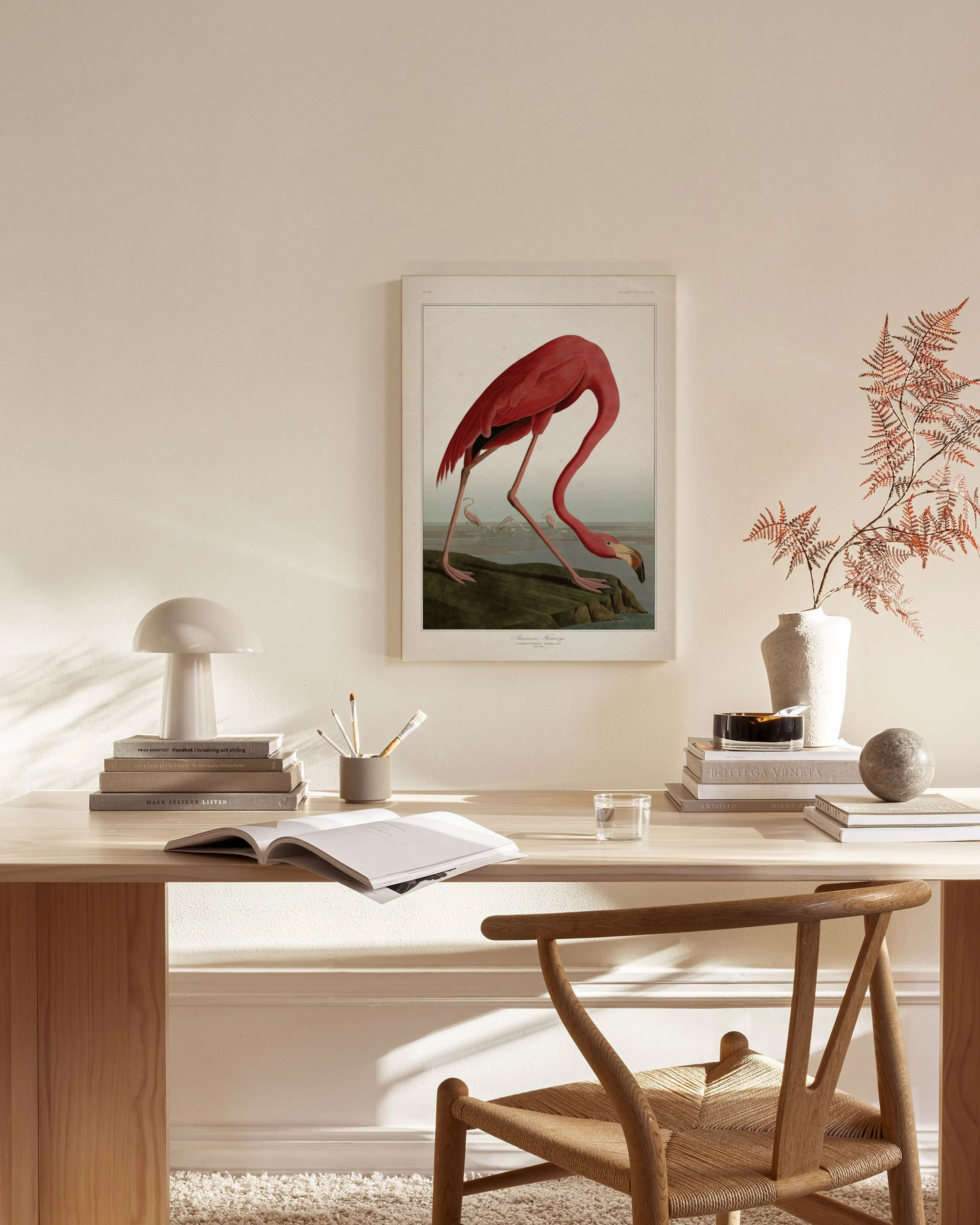 Canvastavla med en röd flamingo som dricker vatten, hängandes i ett ljust modernt vardagsrum.