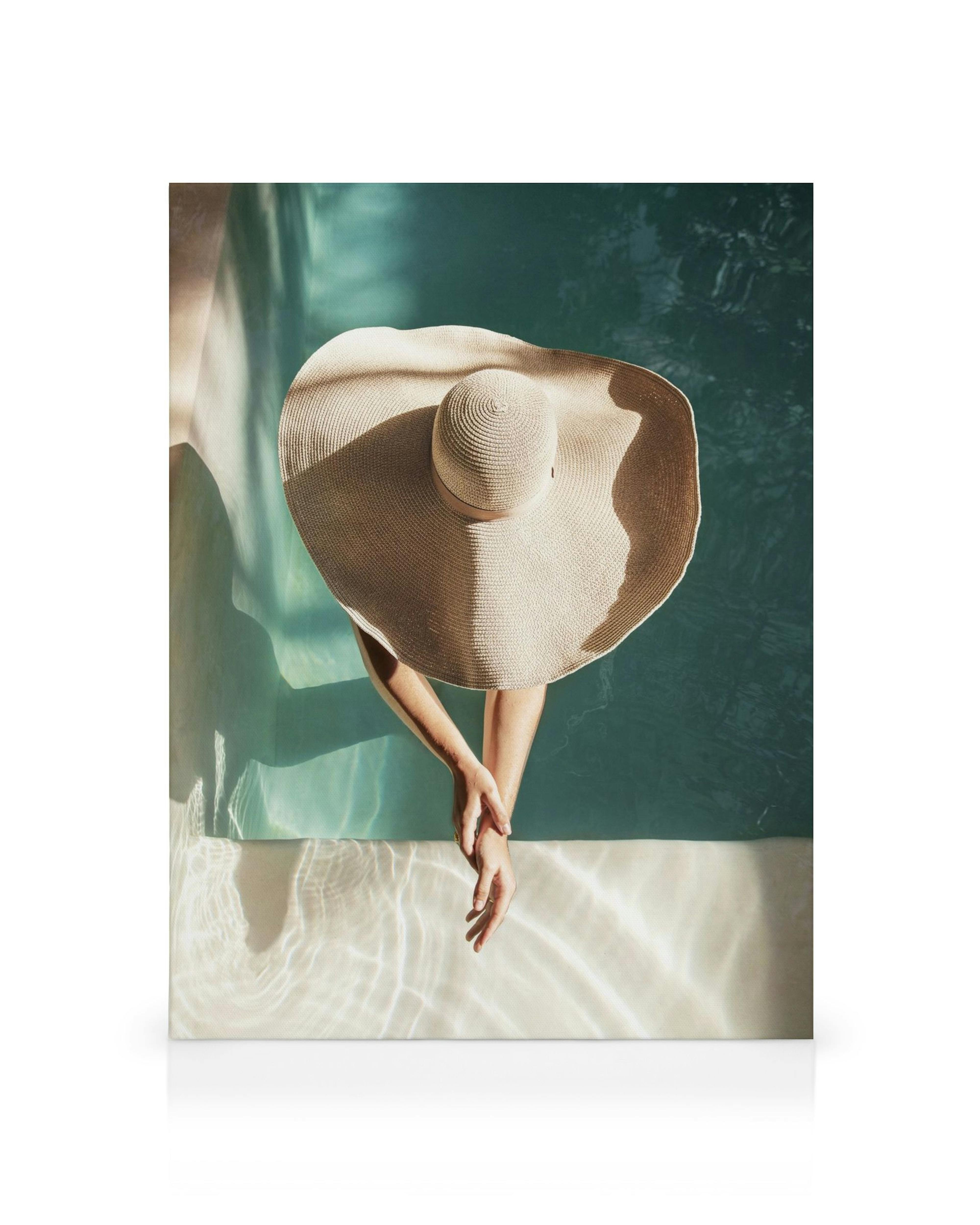 Γυναικείο καπέλο στον ήλιο, χέρια σε πισίνα, καλοκαιρινή ατμόσφαιρα.