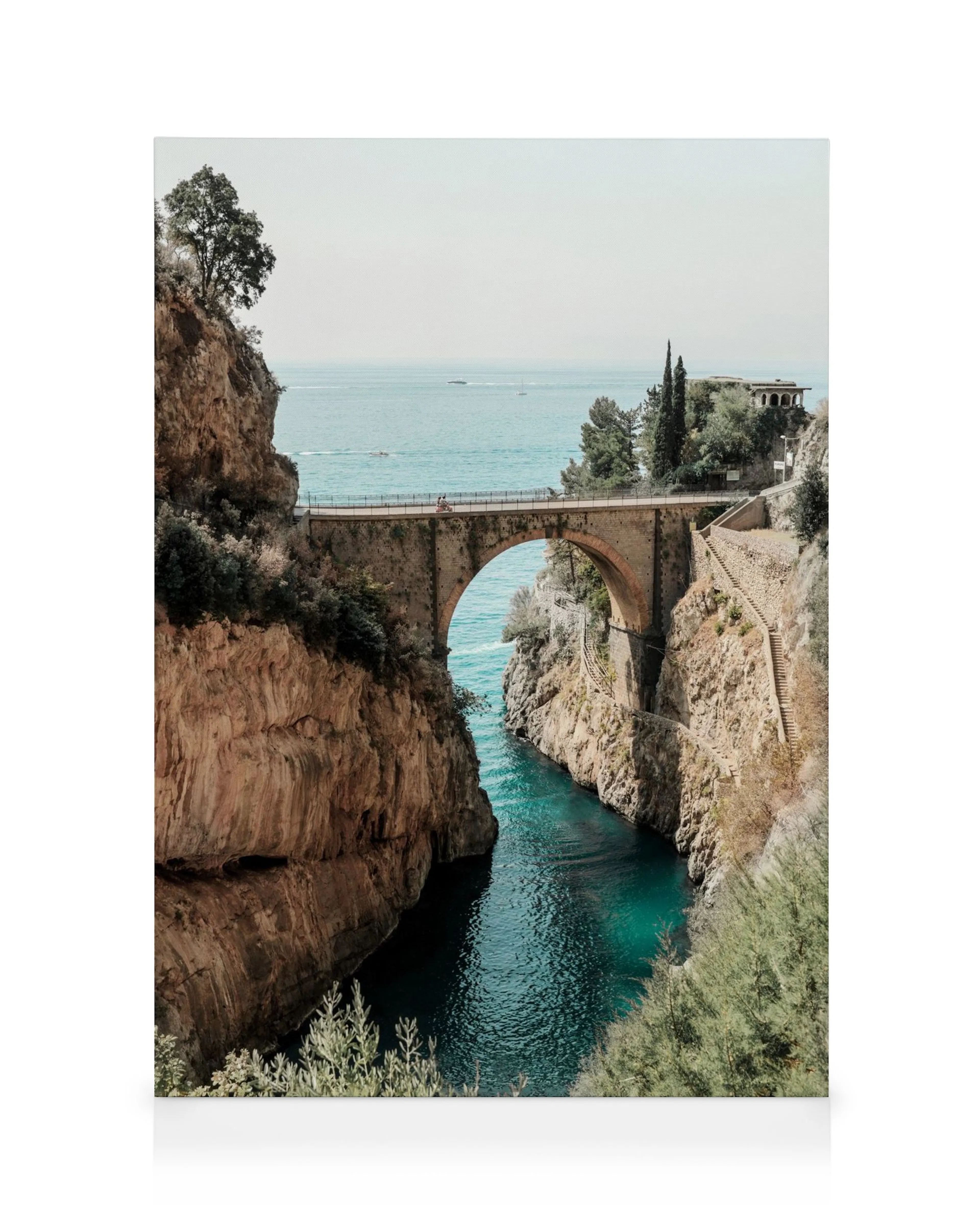 Lienzo del Fiordo di Furore con puente de piedra, acantilados rocosos y agua turquesa del mar, barcos en la distancia.