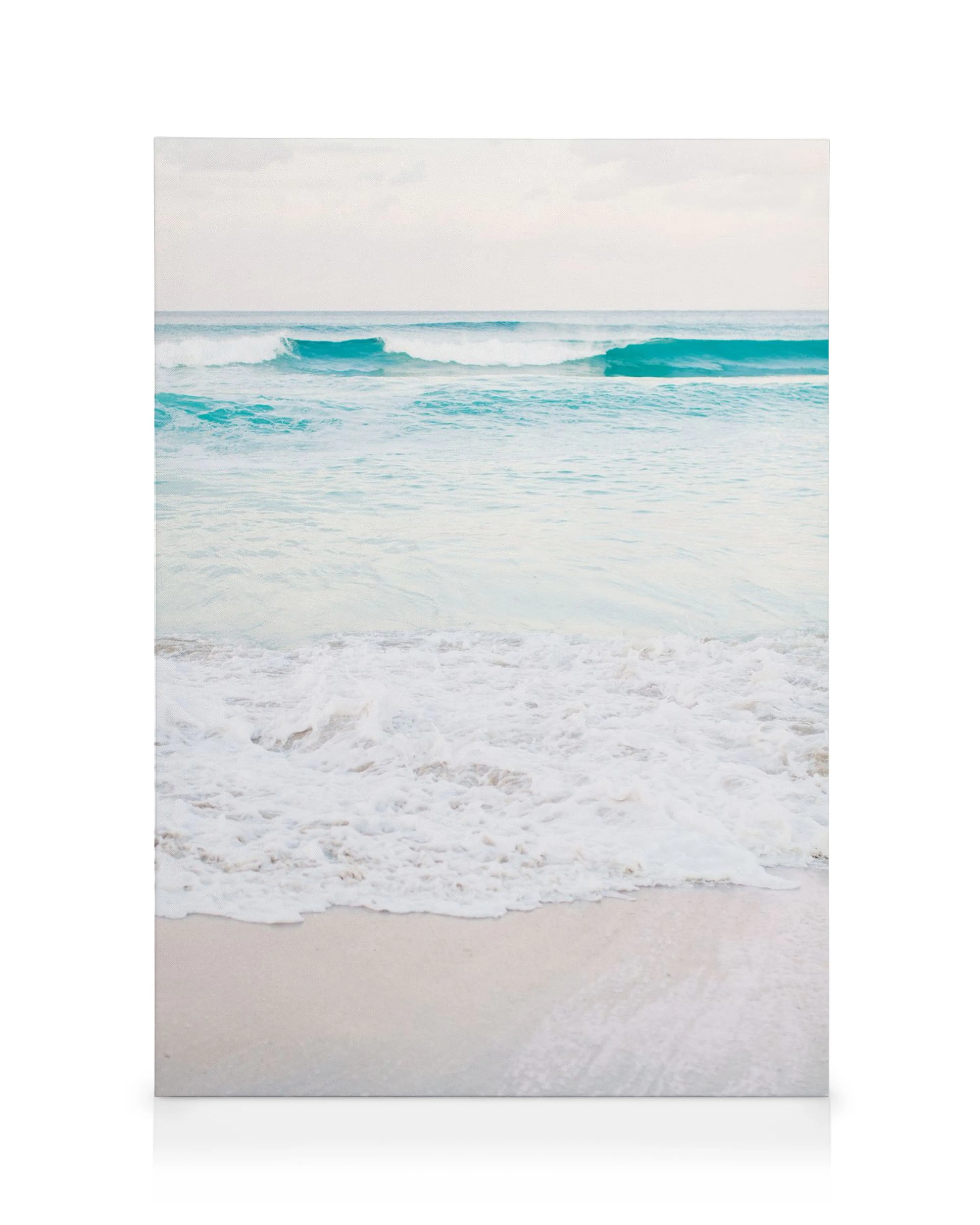 Dreamy pastel beach scene canvas print with light blue waves and white sand.