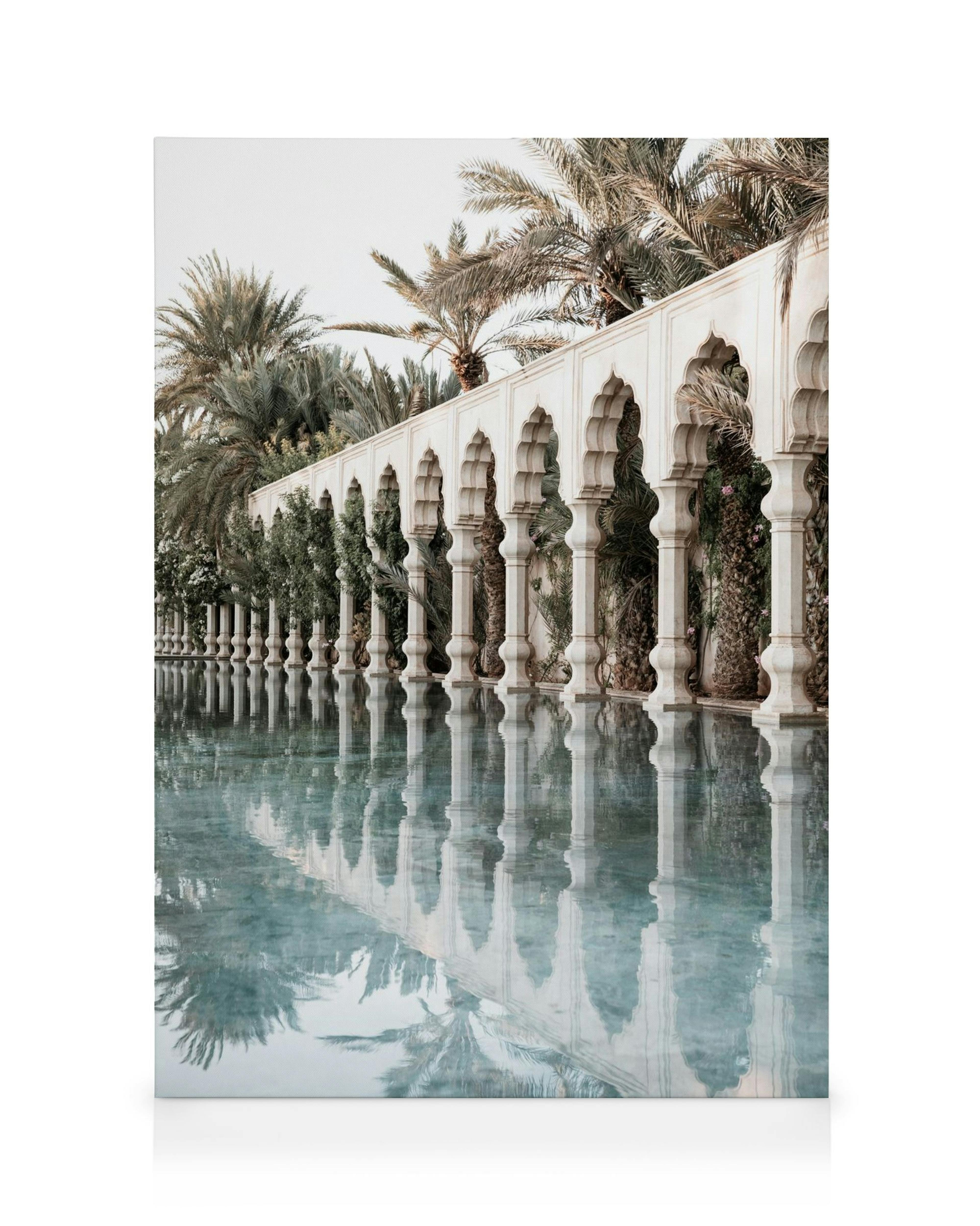 Toile dun bâtiment blanc à colonnes arquées, palmiers, reflet dans leau, tons verts, blancs et bleus