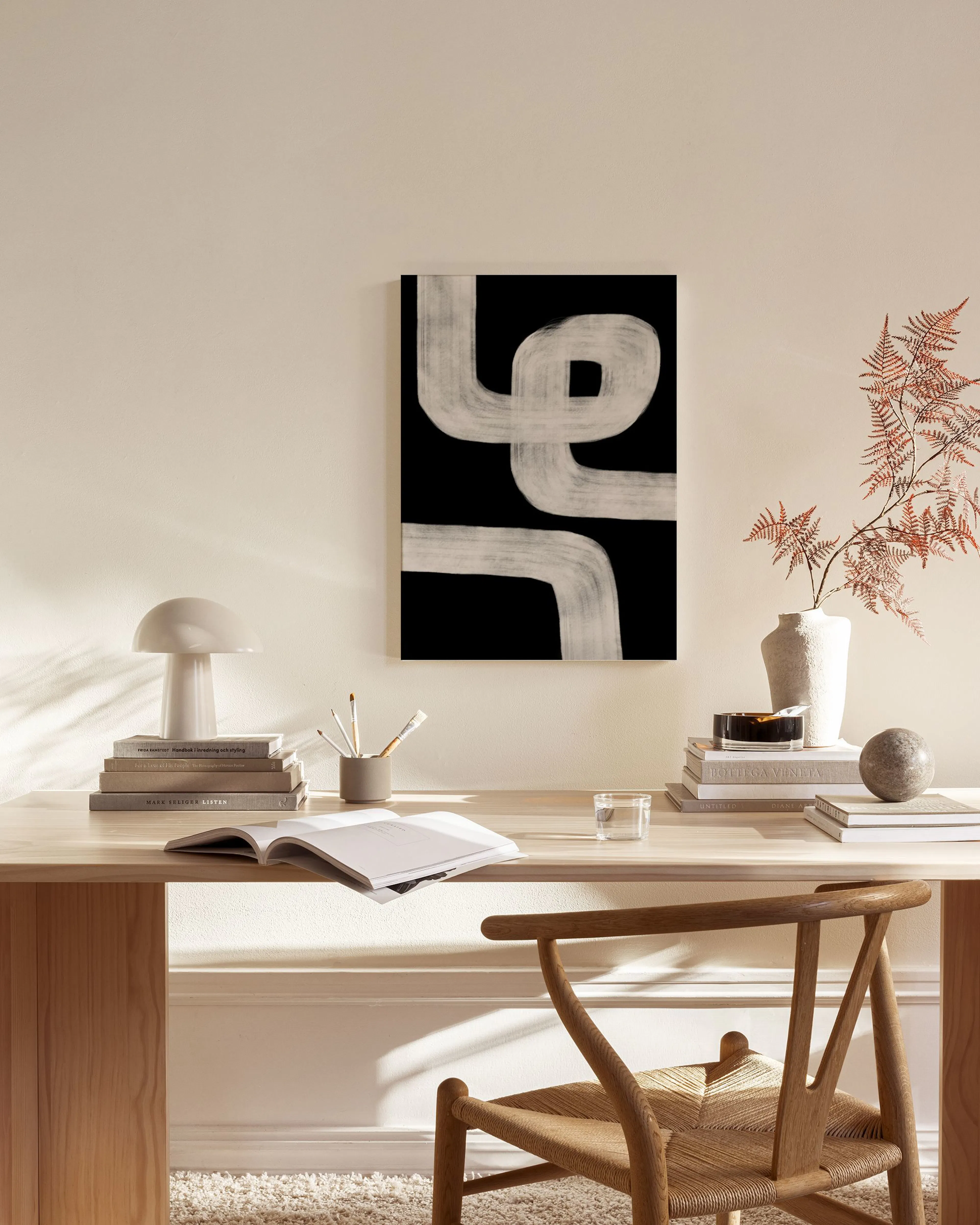 Leinwandbild mit weißen, geschwungenen Linien auf schwarzem Grund, hängt in einem modernen Wohnzimmer über einer Holzbank.