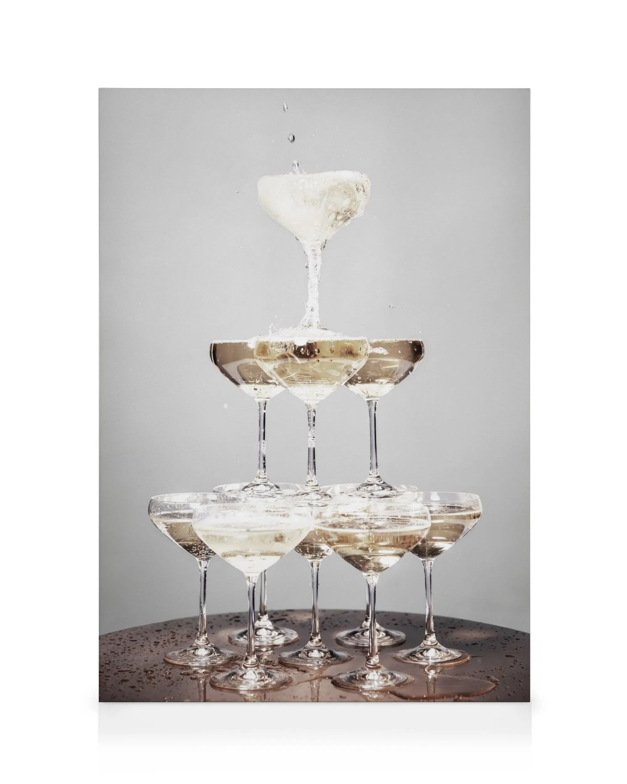 Pirâmide de taças de champanhe com líquido a transbordar, fundo cinzento, para decoração de bar.