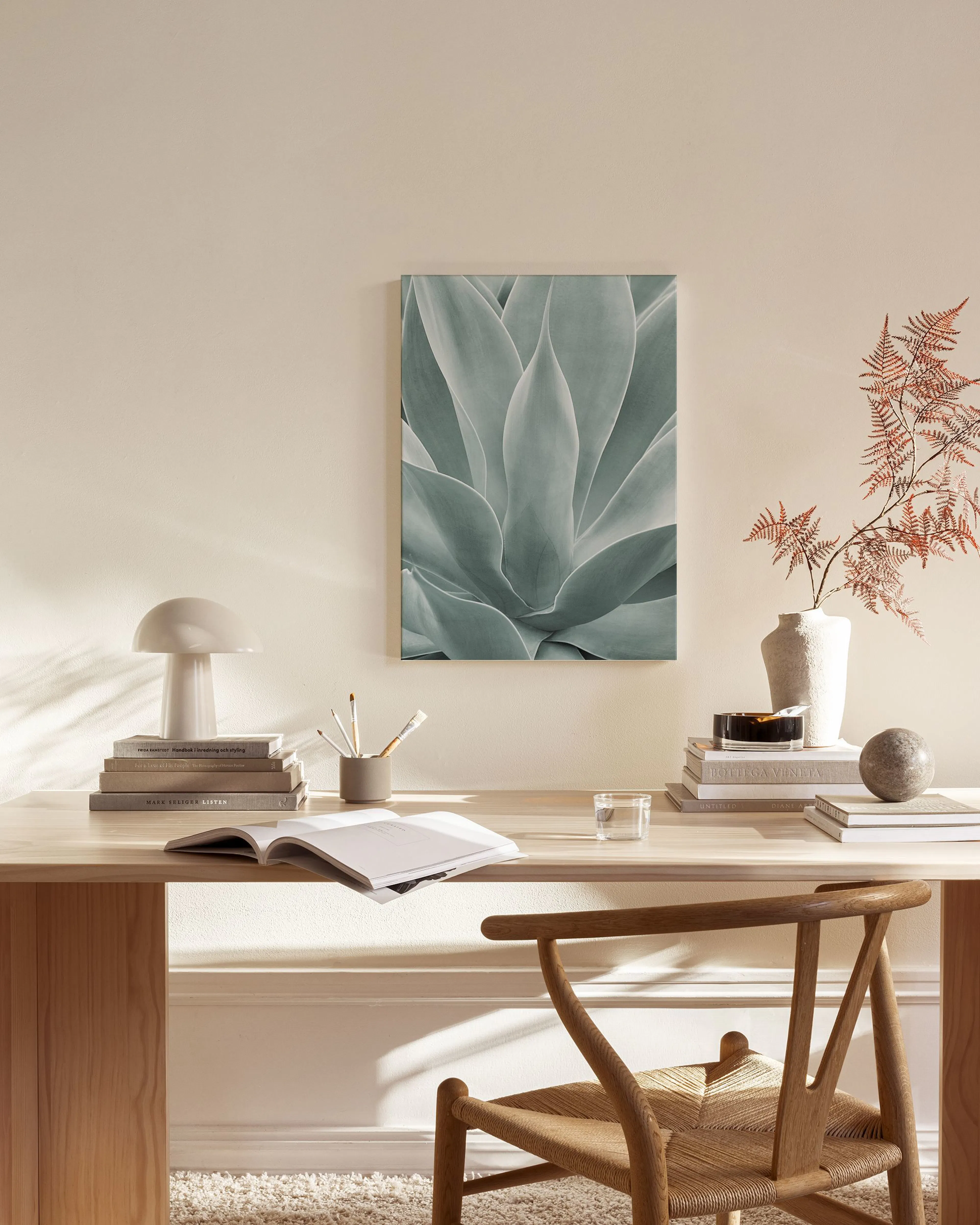 Leinwandbild mit Nahaufnahme einer bläulich-grünen Agavenpflanze, hängend über einem Sideboard in einem Wohnzimmer.