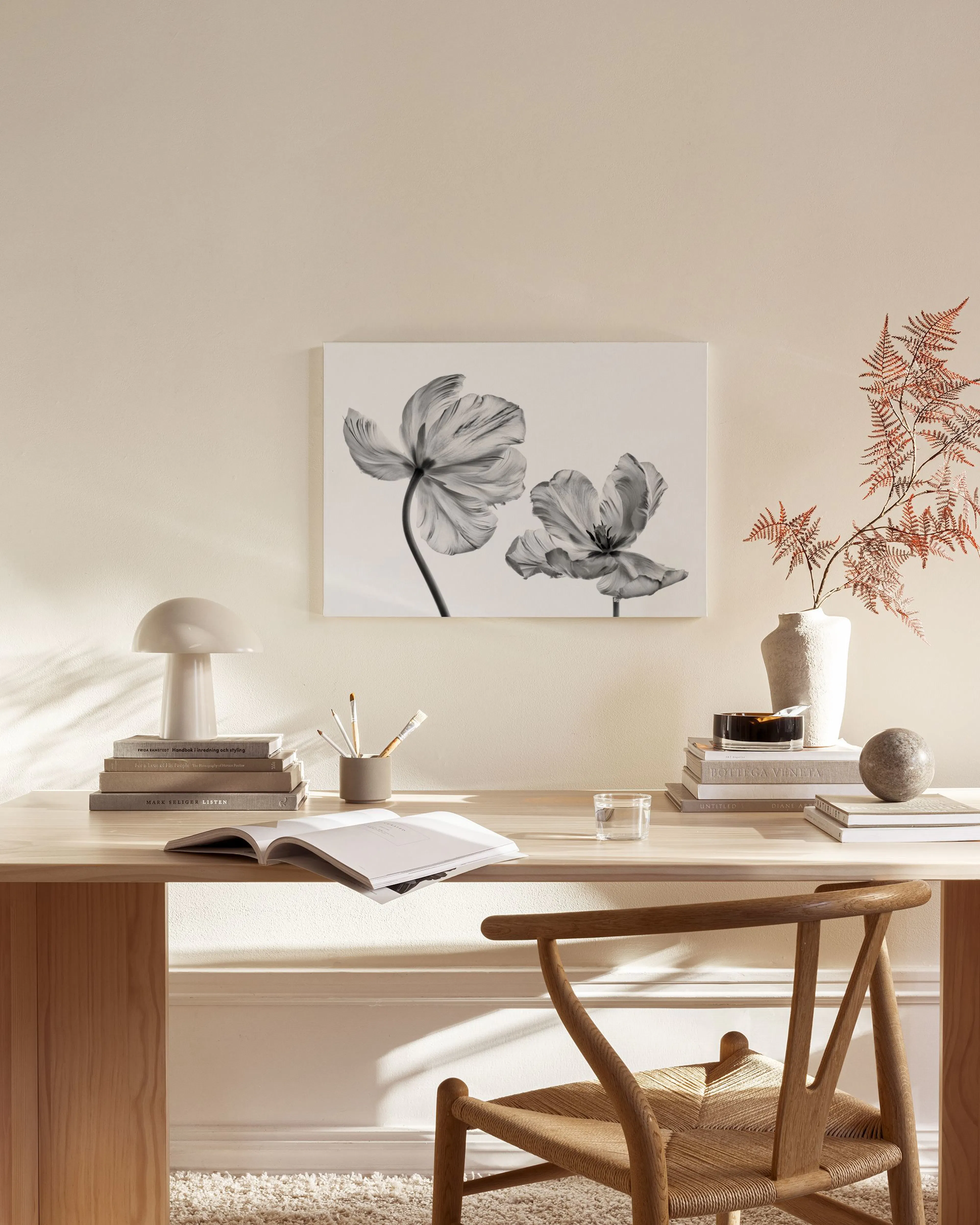 Leinwandbild mit zwei schwarz-weißen Mohnblumen in einem minimalistischen Wohnzimmer über einem Sideboard.