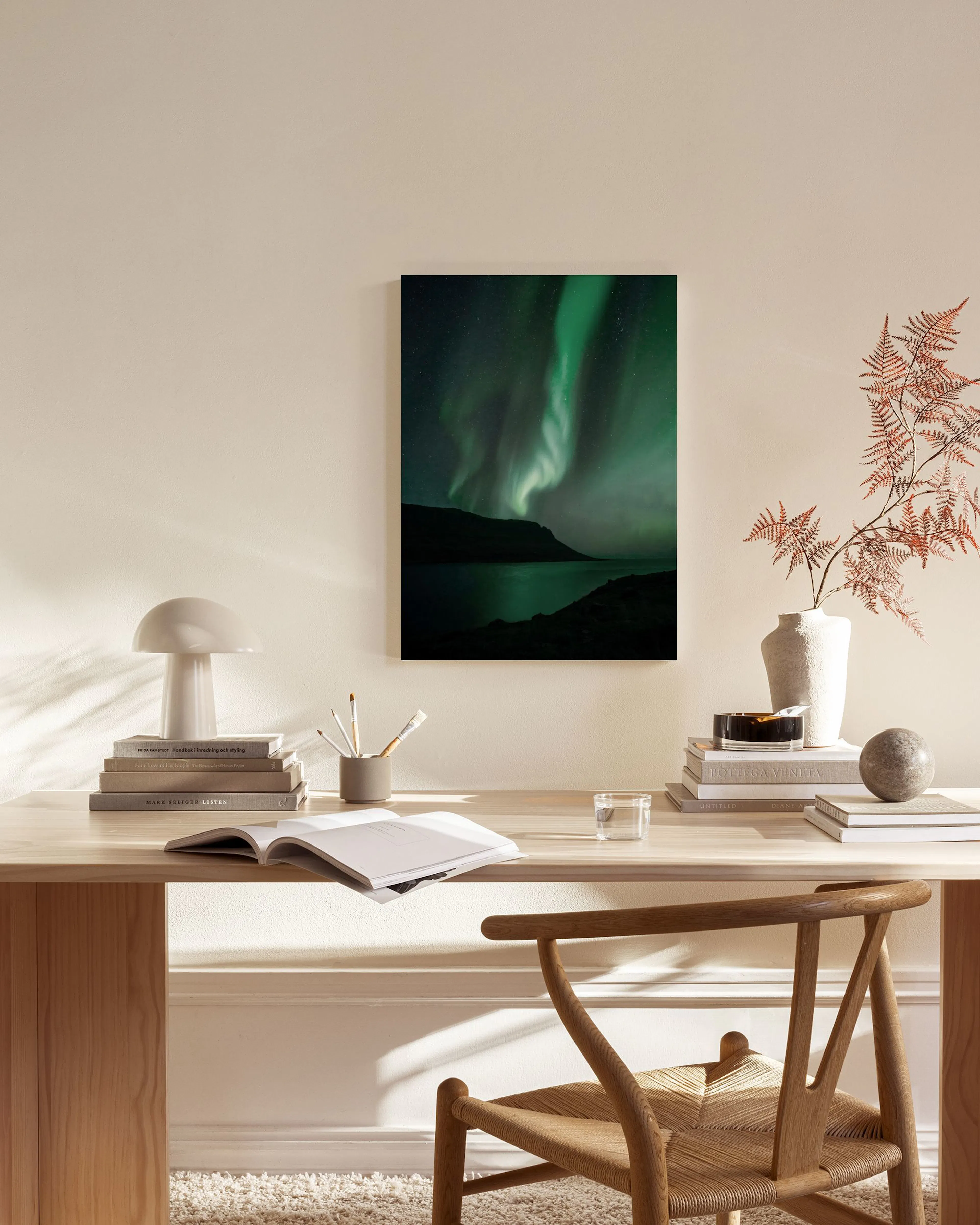 Leinwandbild mit Nordlichtern über einem See in einem modernen Wohnzimmer mit Holzmöbeln.