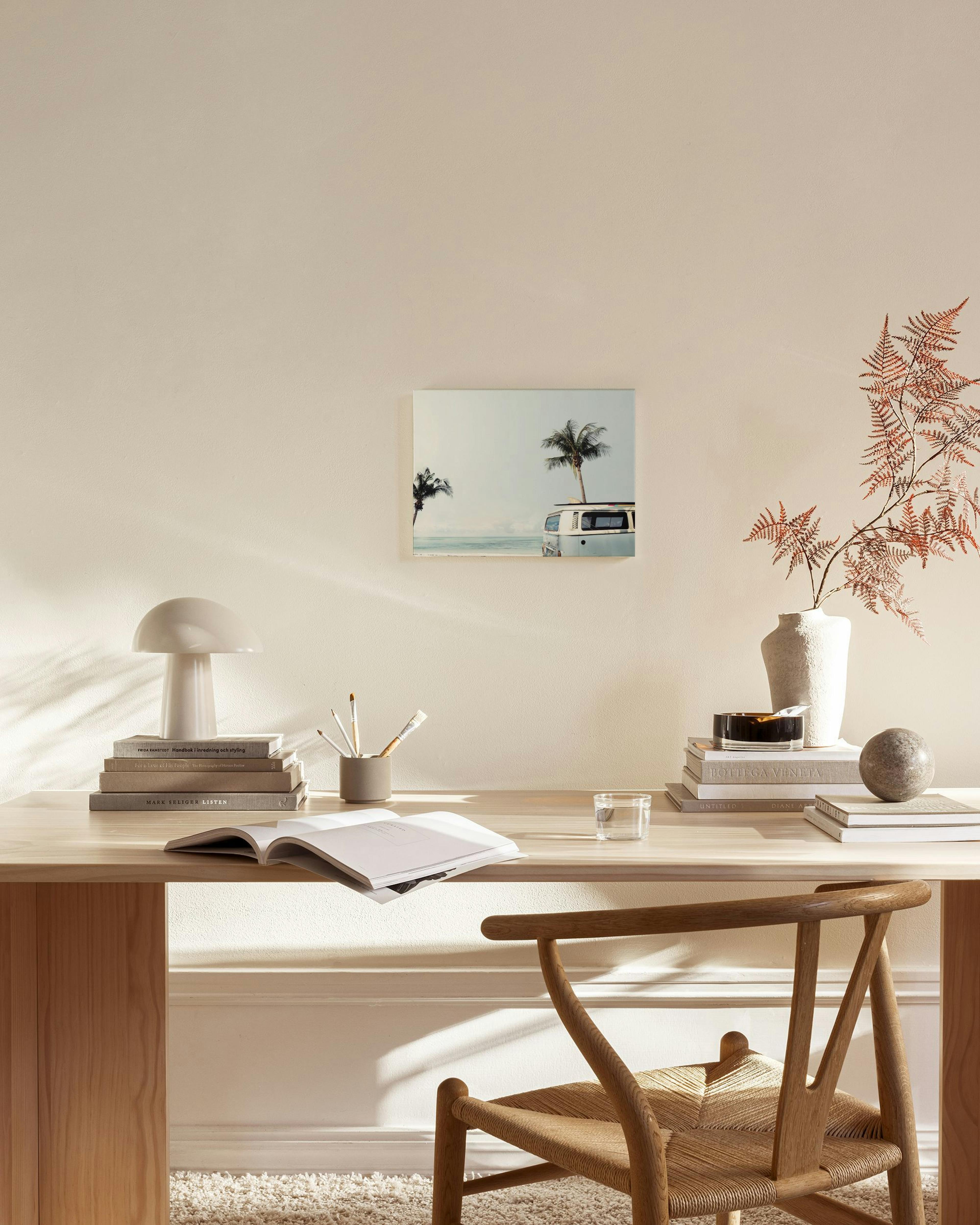 Leinwandbild eines VW Busses mit Surfbrett am Strand, Palmen und Meer im Hintergrund, ideal für Wohnzimmer.