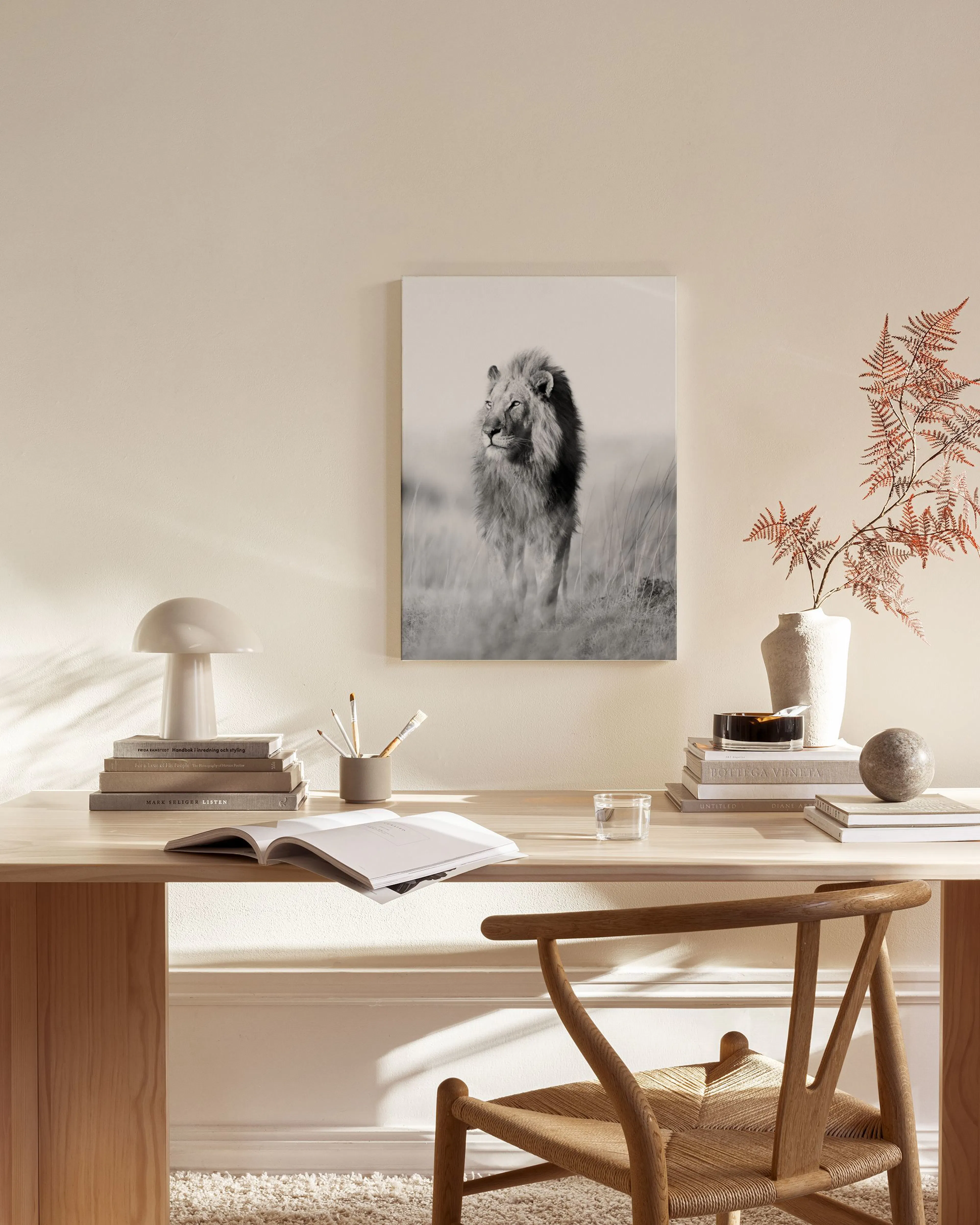 Schwarz-weißes Leinwandbild eines Löwen in einem modernen Wohnzimmer über einem Sideboard.