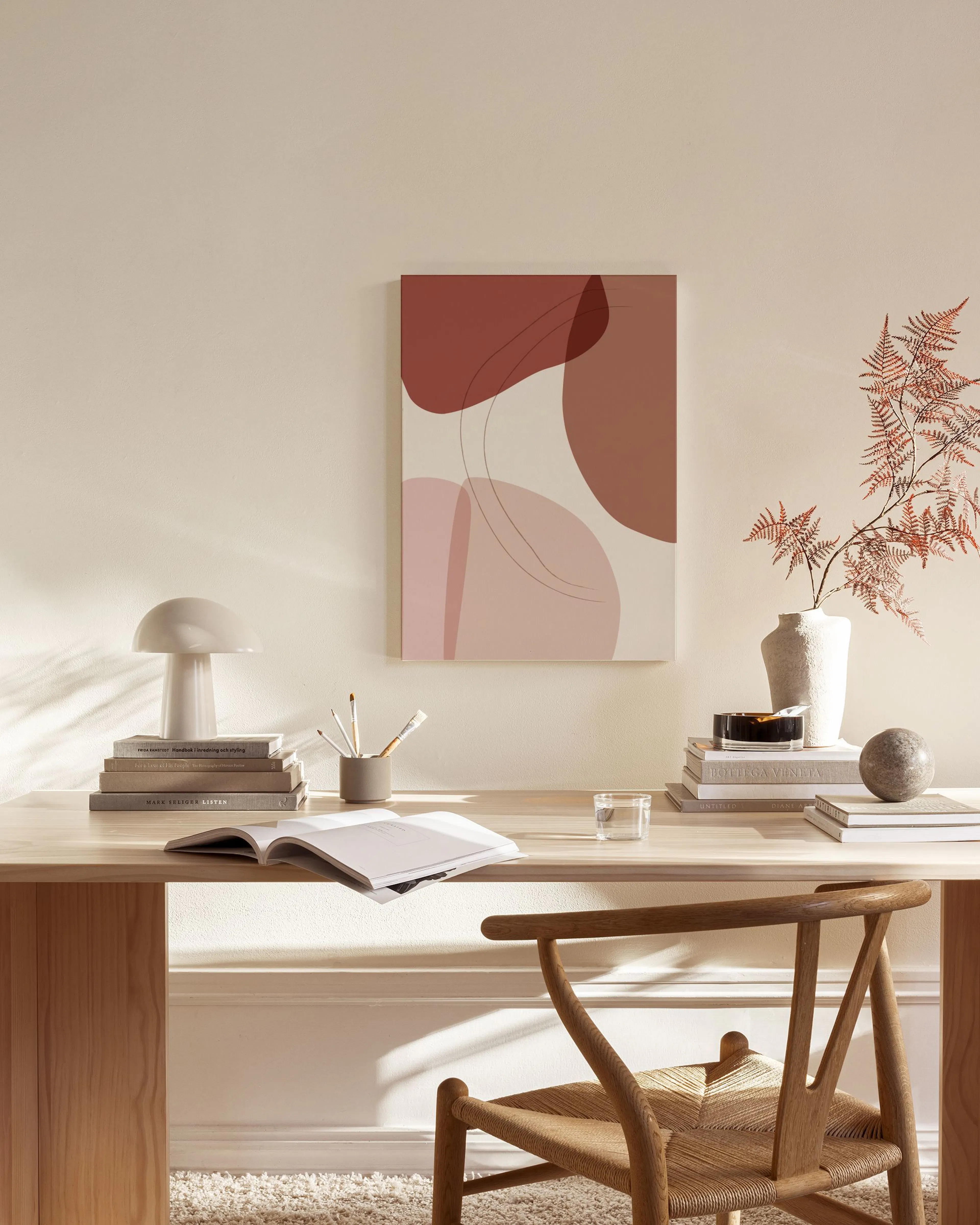 Toile murale abstraite aux formes organiques rouges et beiges avec fines lignes noires, suspendue au-dessus dun banc dans un sal