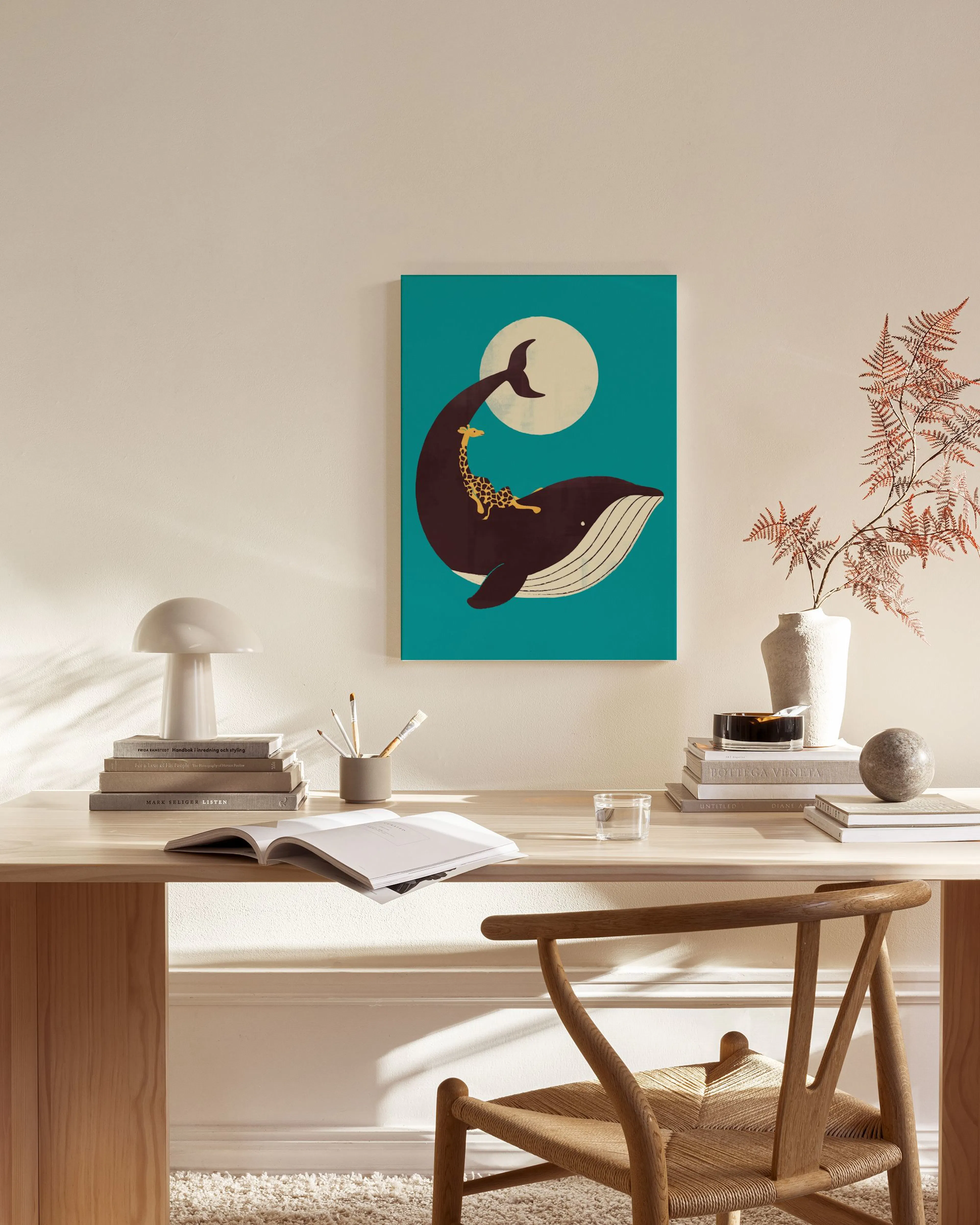 Stampa su tela di una balena con giraffa e luna, appesa in un moderno soggiorno con mobili in legno.
