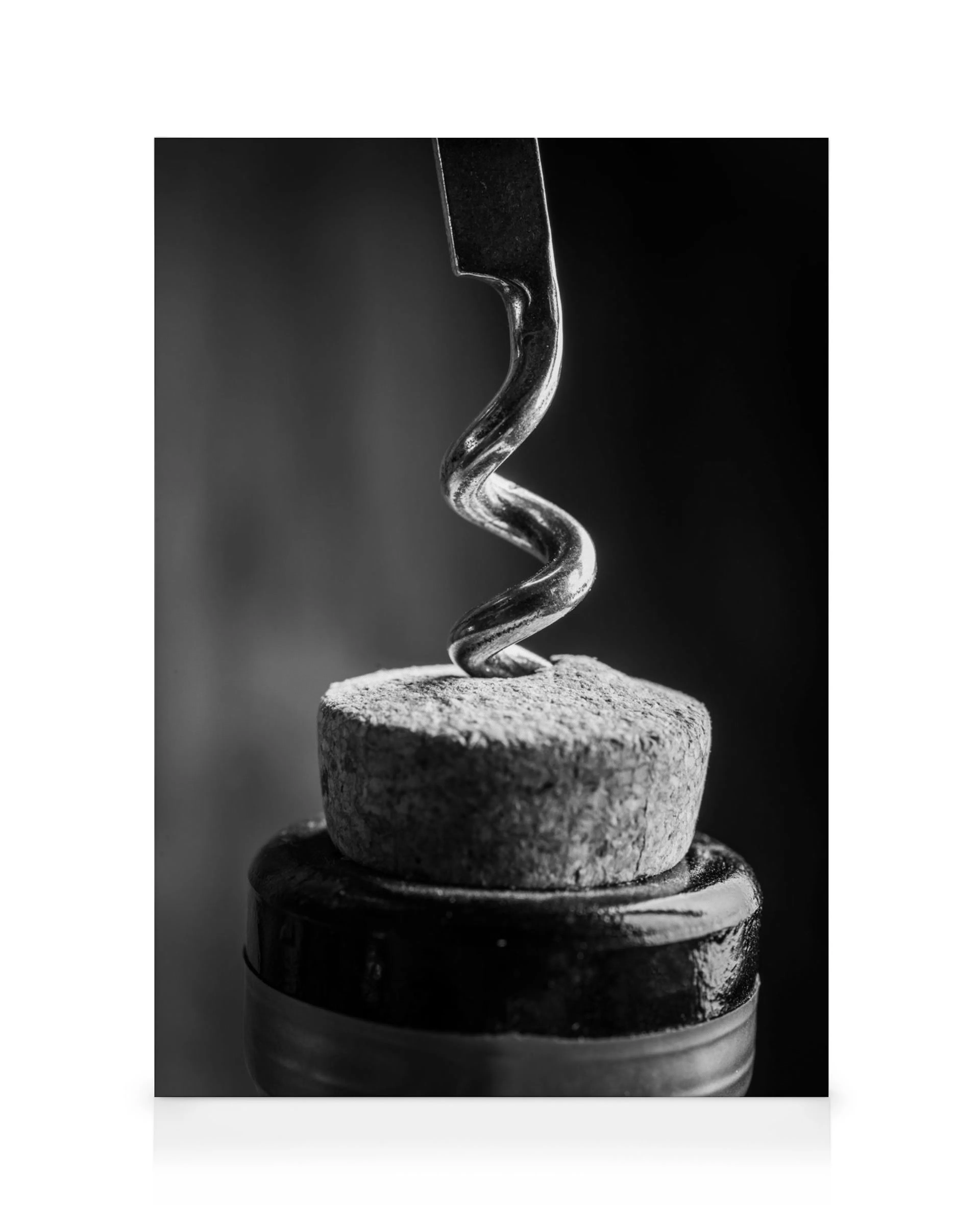Black and white corkscrew entering a wine bottle cork, close-up, minimalist still life, kitchen art.