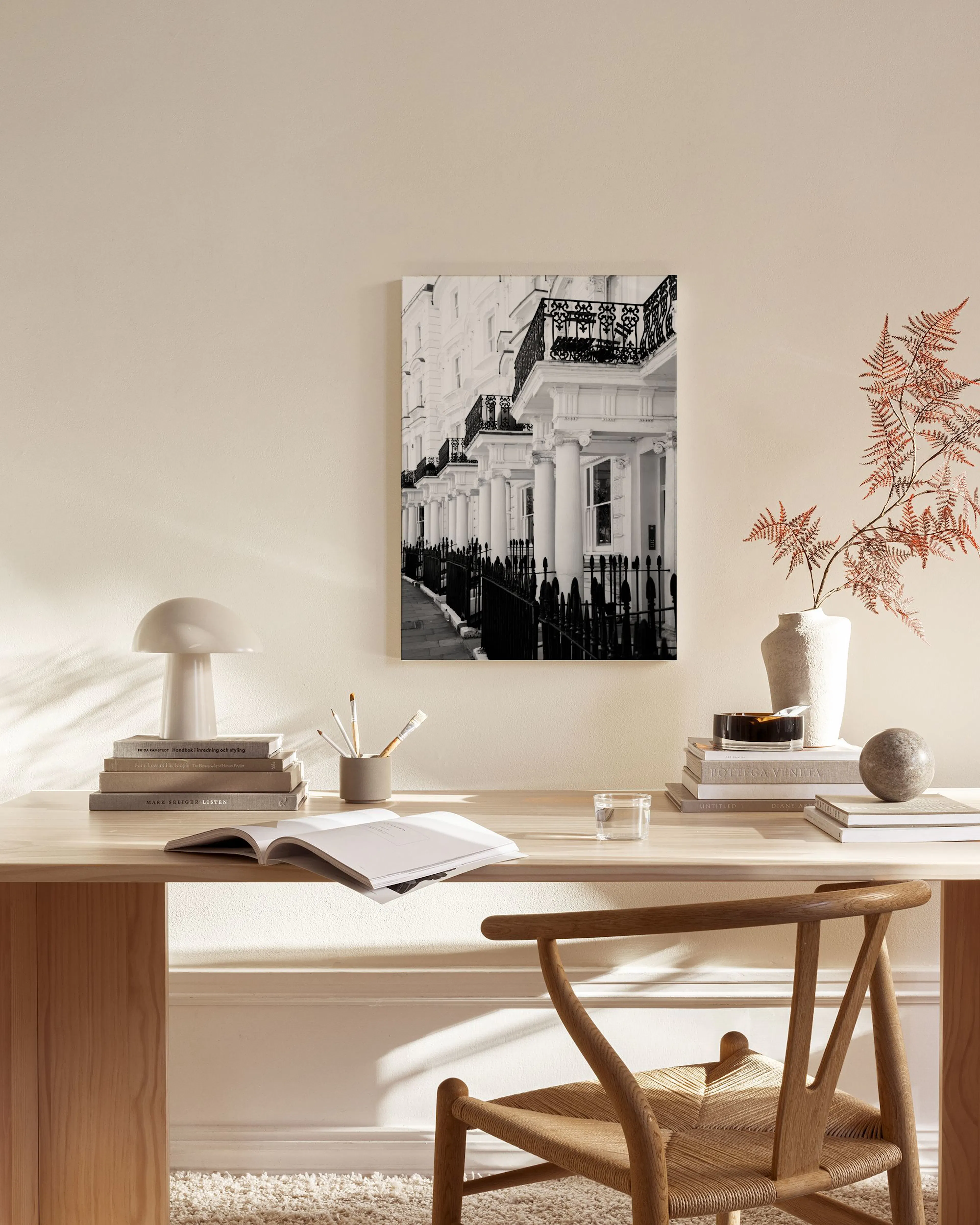 Black and white cityscape print of terraced houses with ornate railings, displayed in a bright living room.